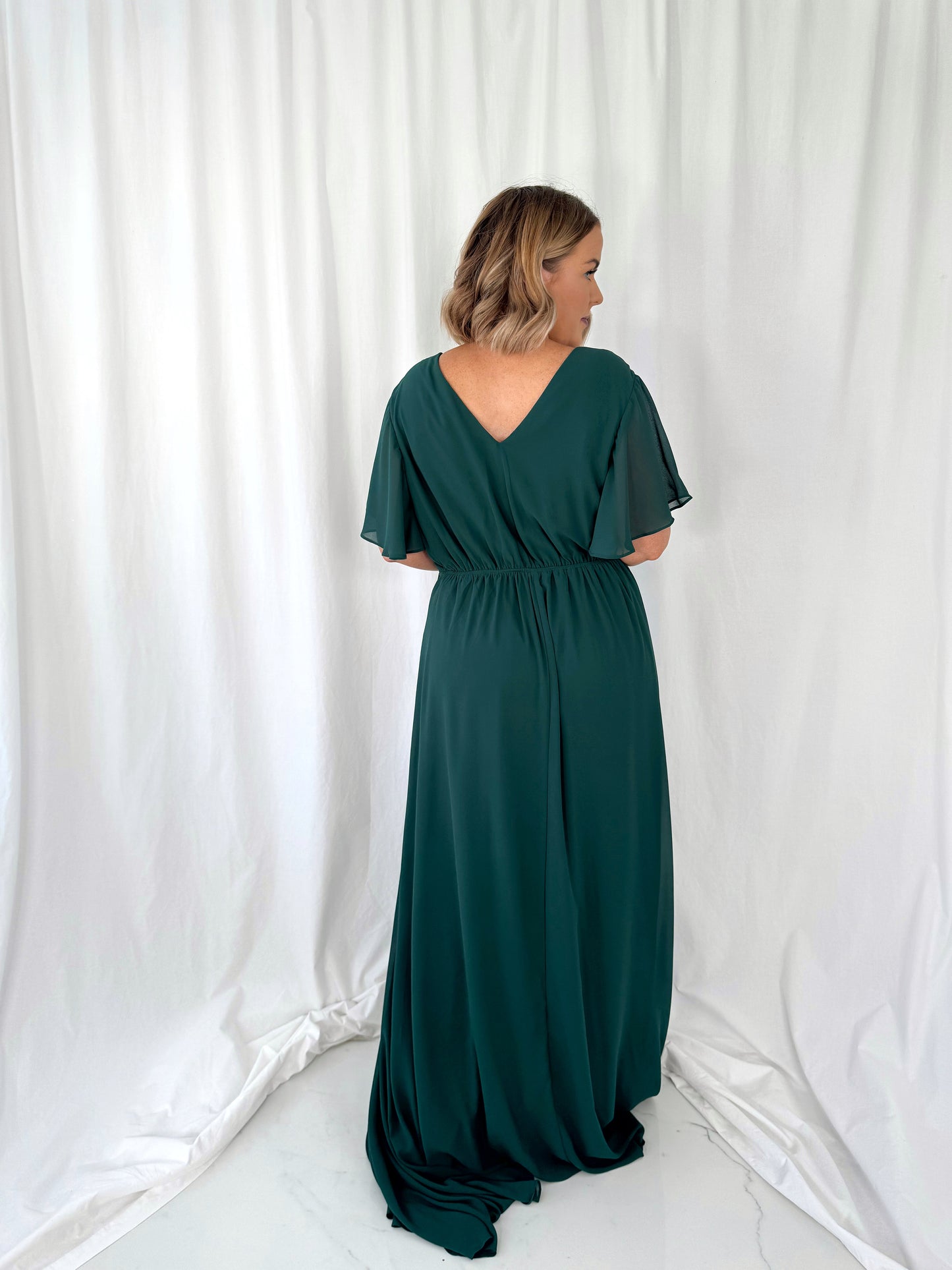 a woman in a green dress holding a cell phone