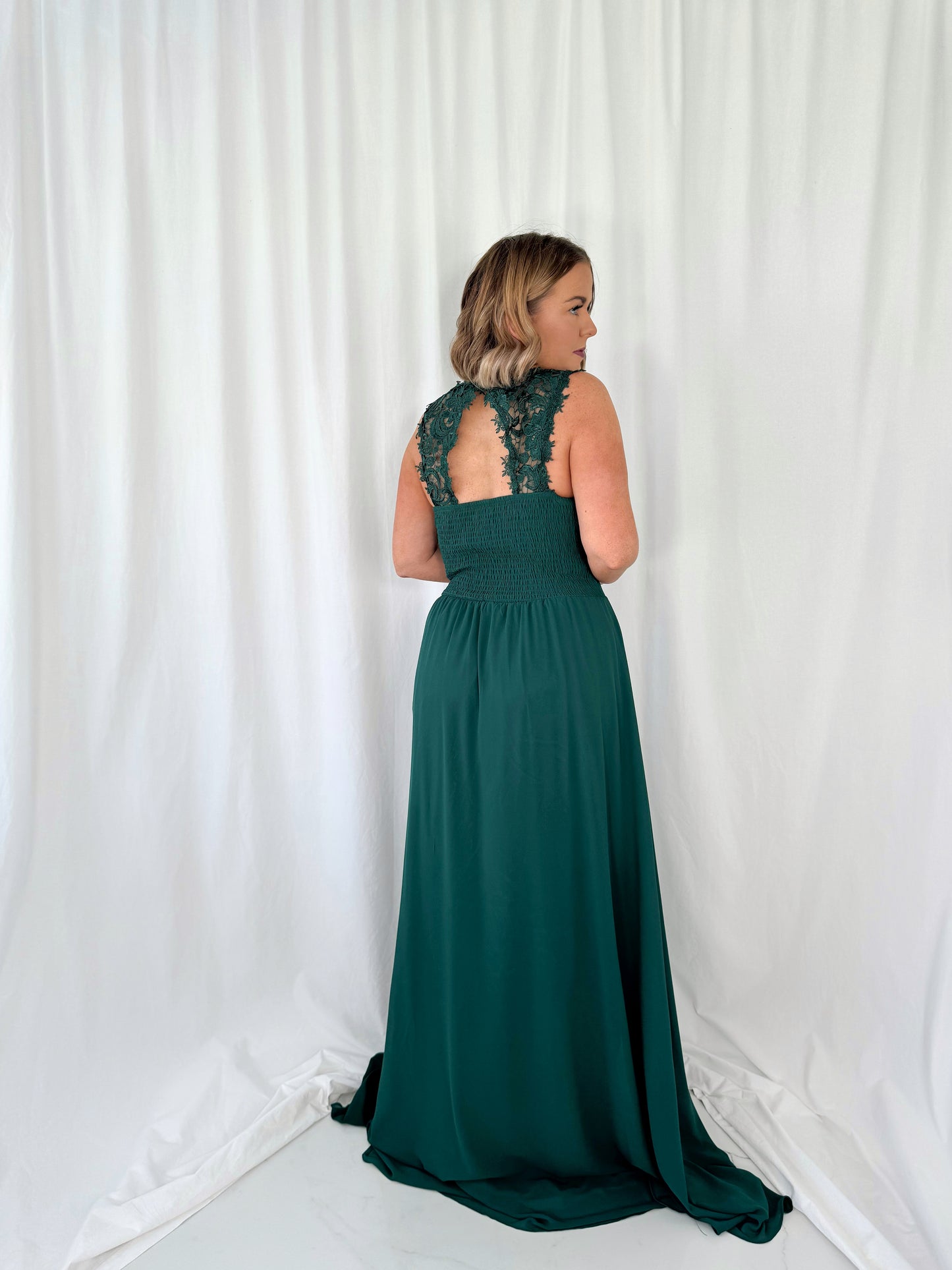 a woman in a green dress talking on a cell phone