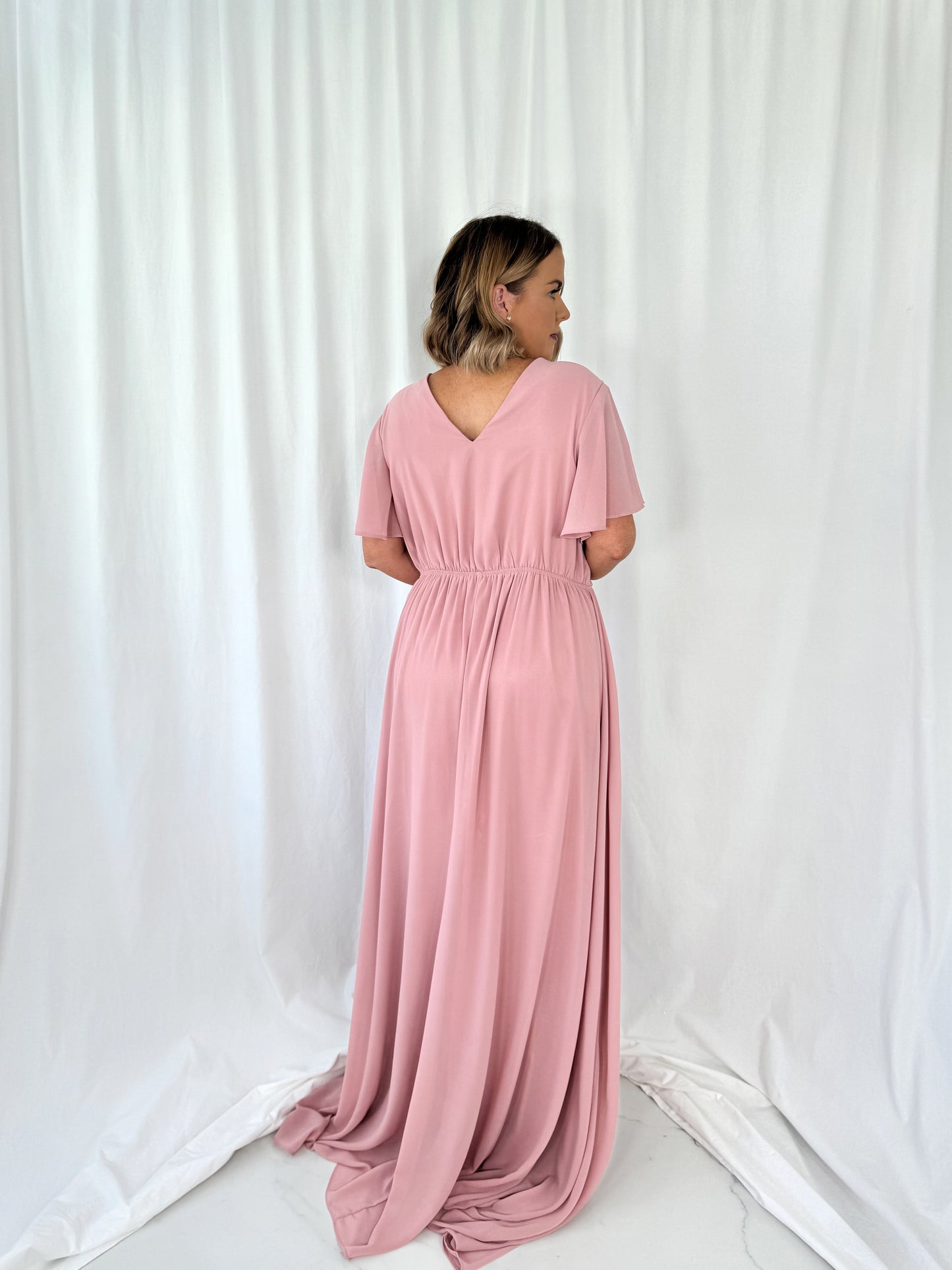 a woman in a pink dress in a white dress