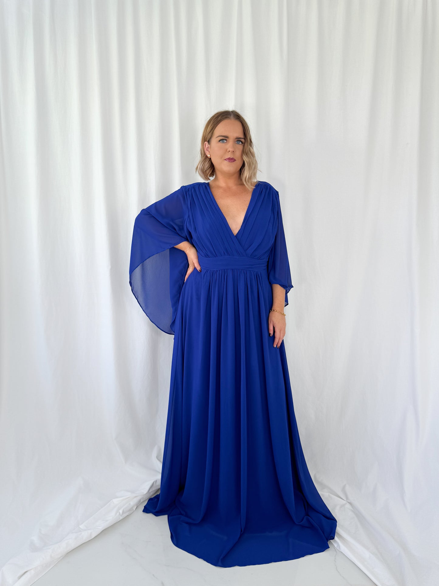 a woman in a blue dress holding a frisbee