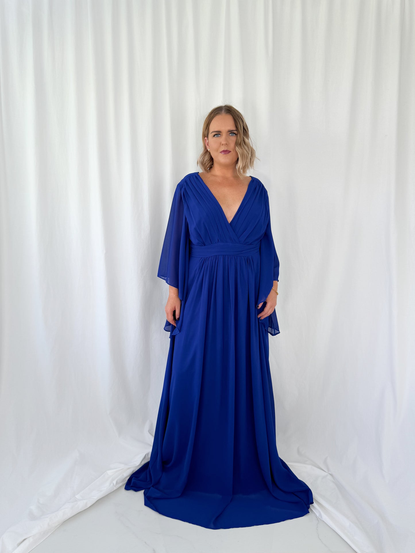 a woman in a blue dress standing in a white dress