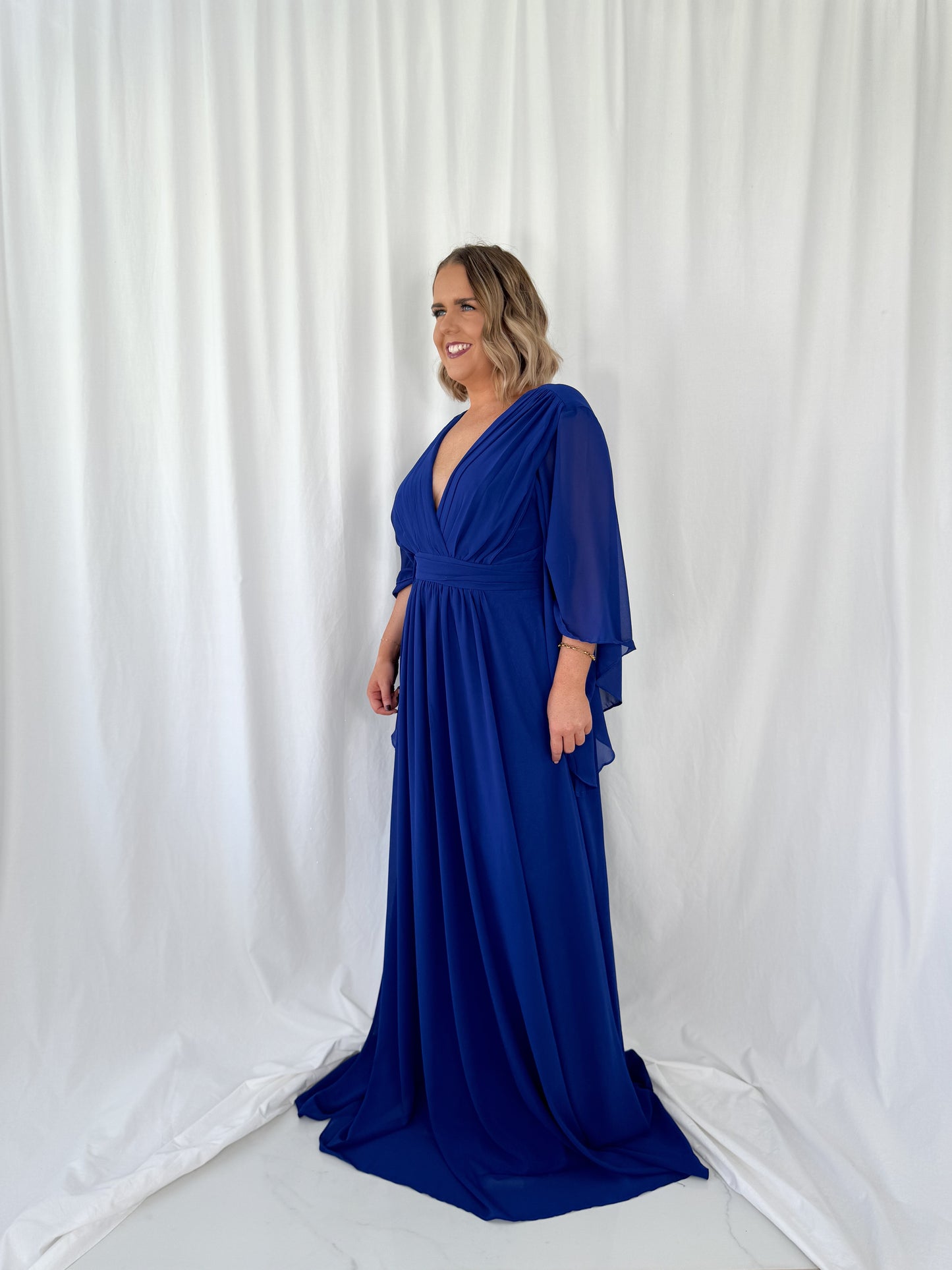 a man in a blue dress standing in a white dress