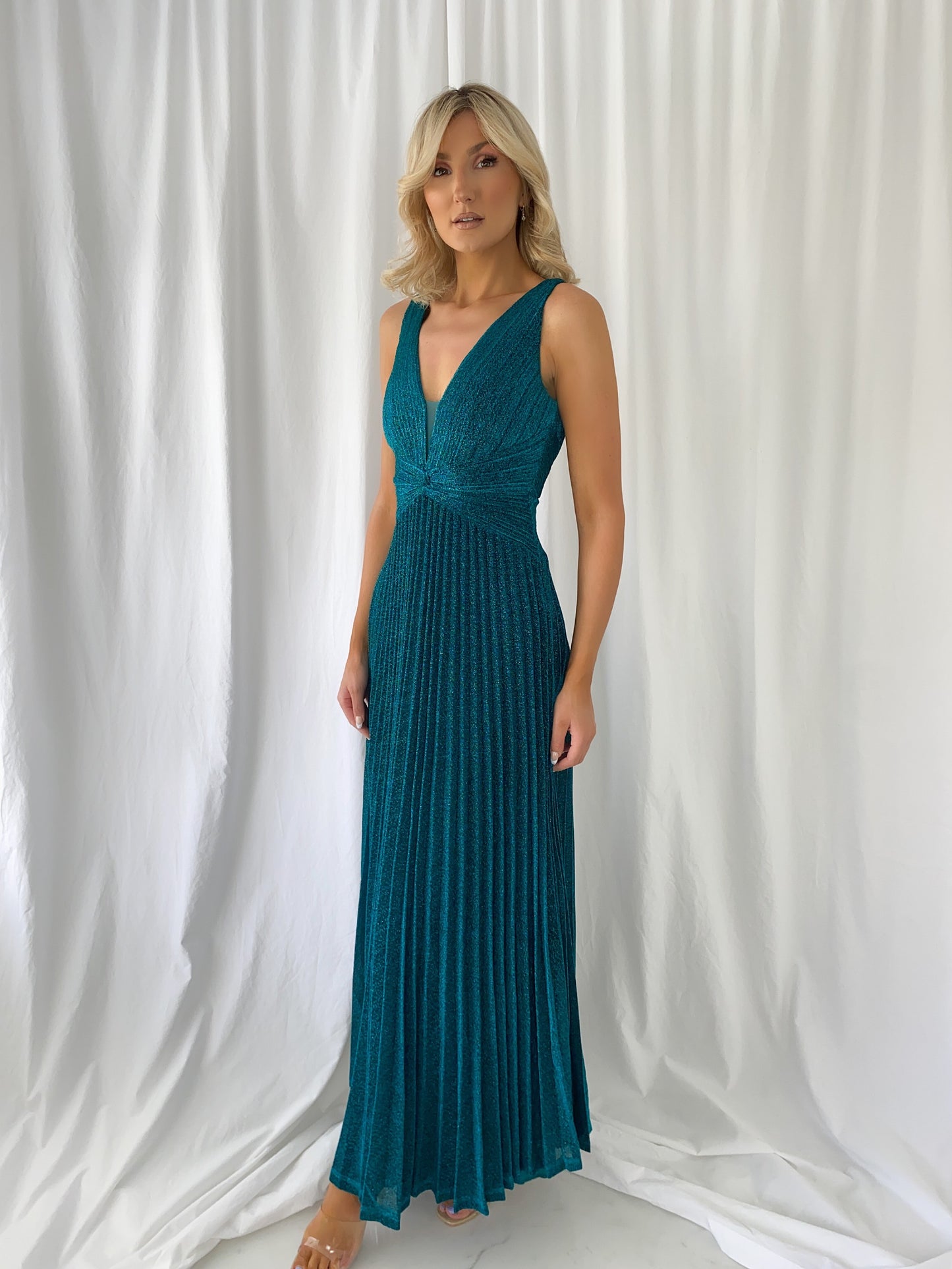 a woman in a blue dress is talking on a cell phone