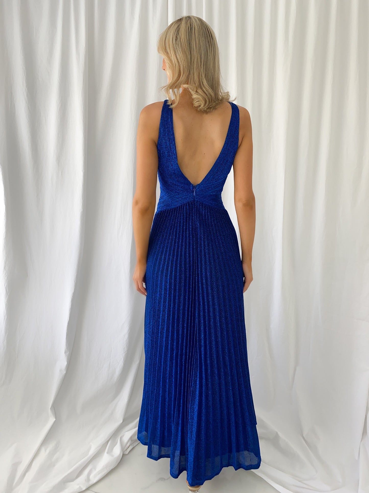 a woman in a blue dress talking on a cell phone