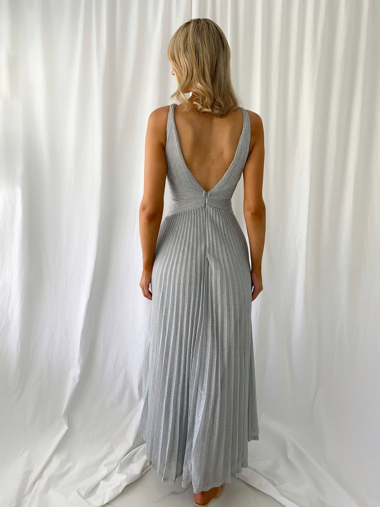 a woman in a white dress talking on a cell phone