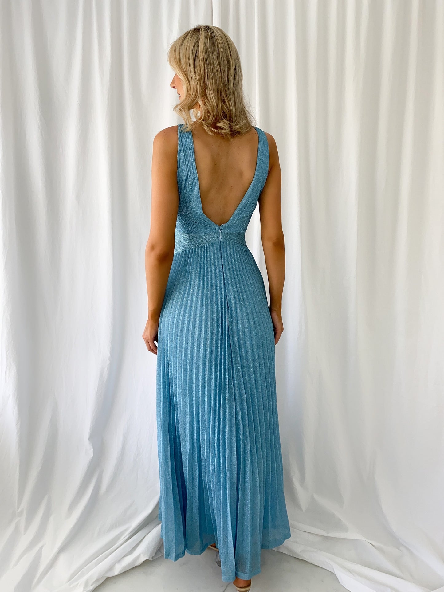 a woman in a blue dress standing in a white dress