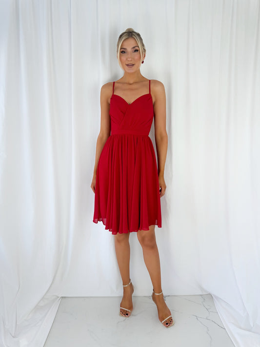 a woman in a red dress standing in the snow
