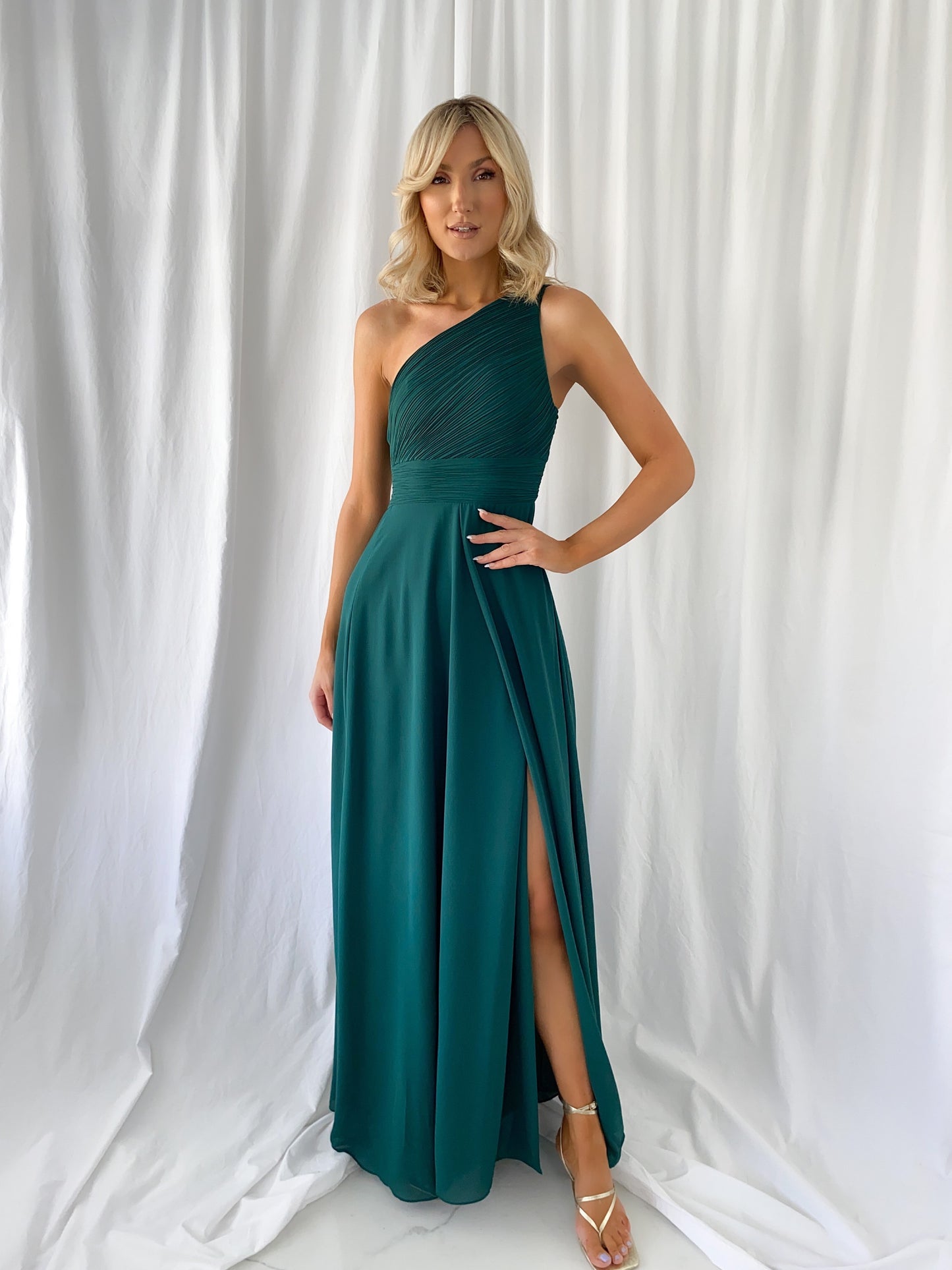 a woman in a green dress holding a cell phone