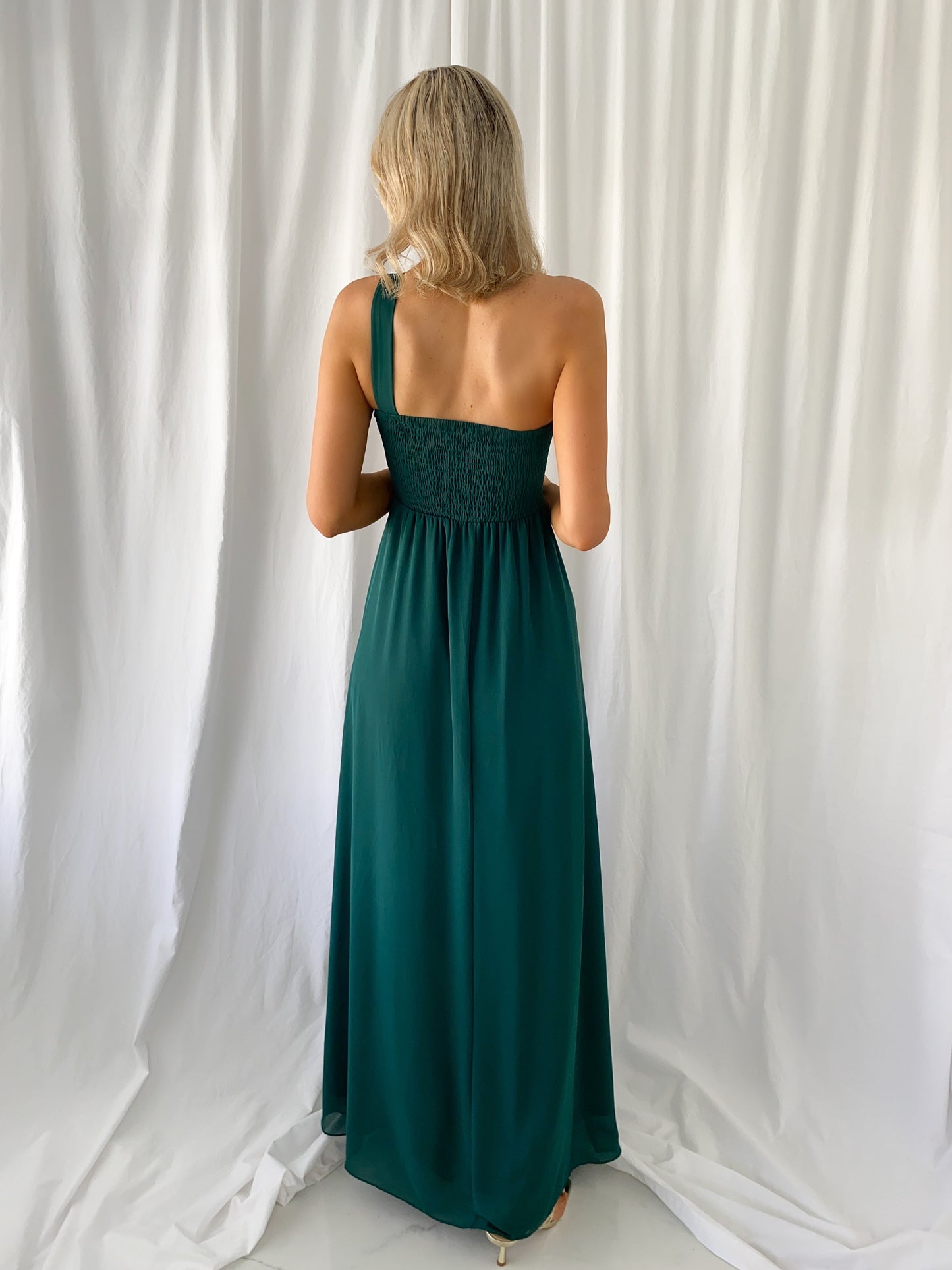 a woman in a green dress holding a cell phone