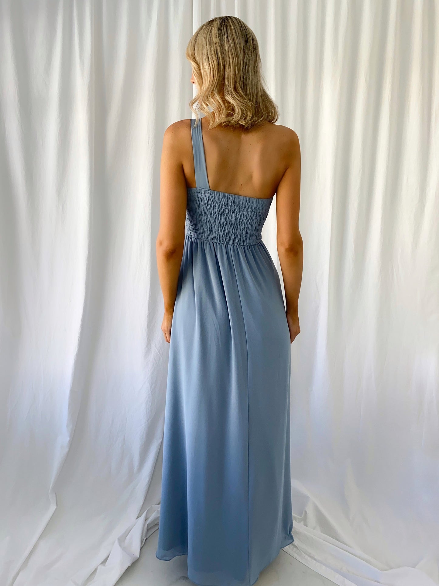 a woman in a dress standing in a white dress
