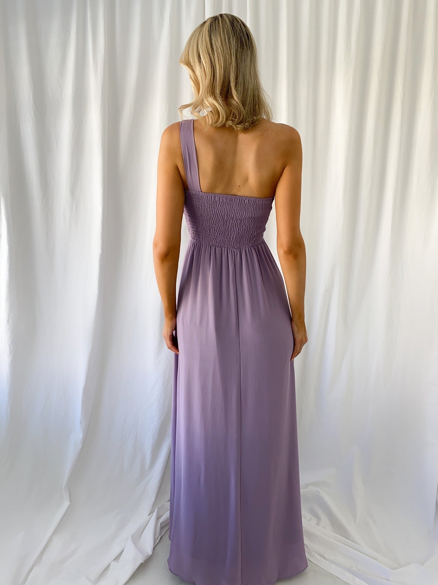 a woman in a pink dress standing in a white dress