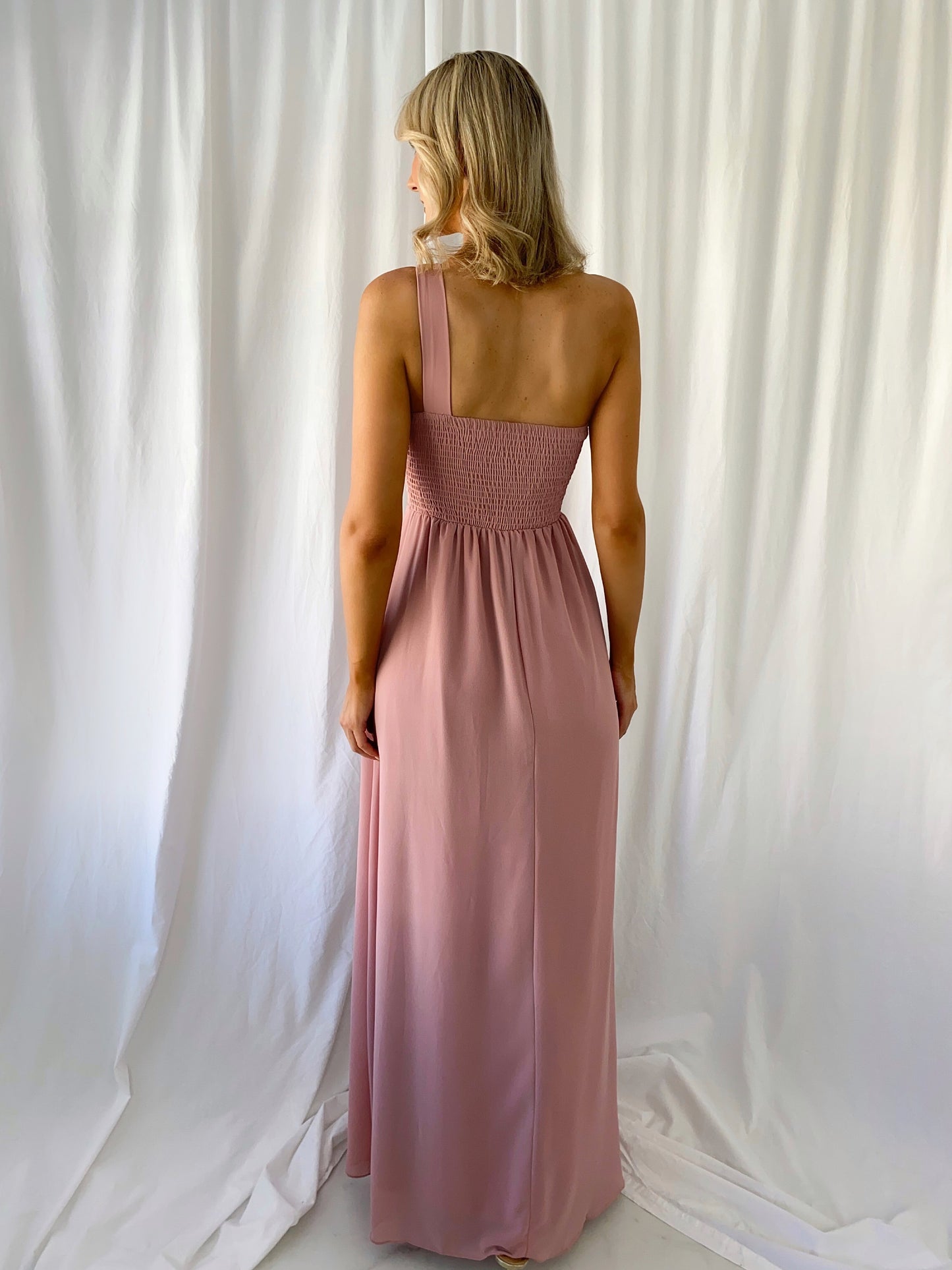 a woman in a pink dress standing in a white dress