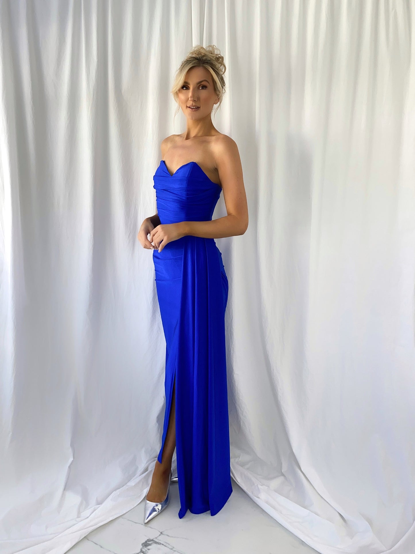 a woman in a blue dress standing in a white dress