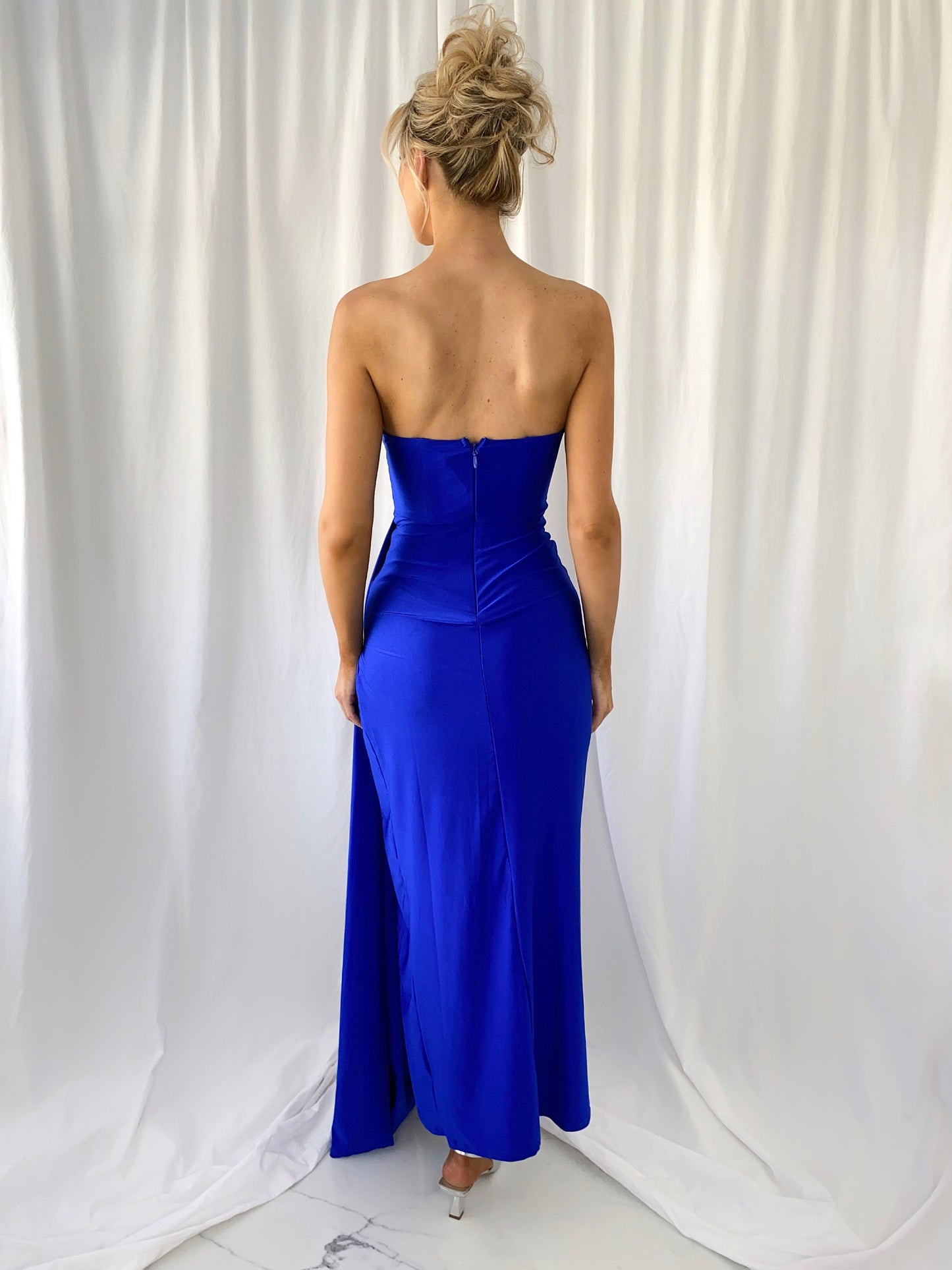 a woman in a blue dress standing in a white dress