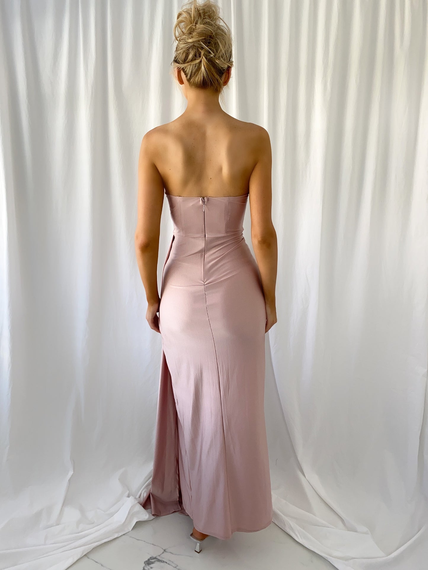 a woman in a pink dress standing next to a man