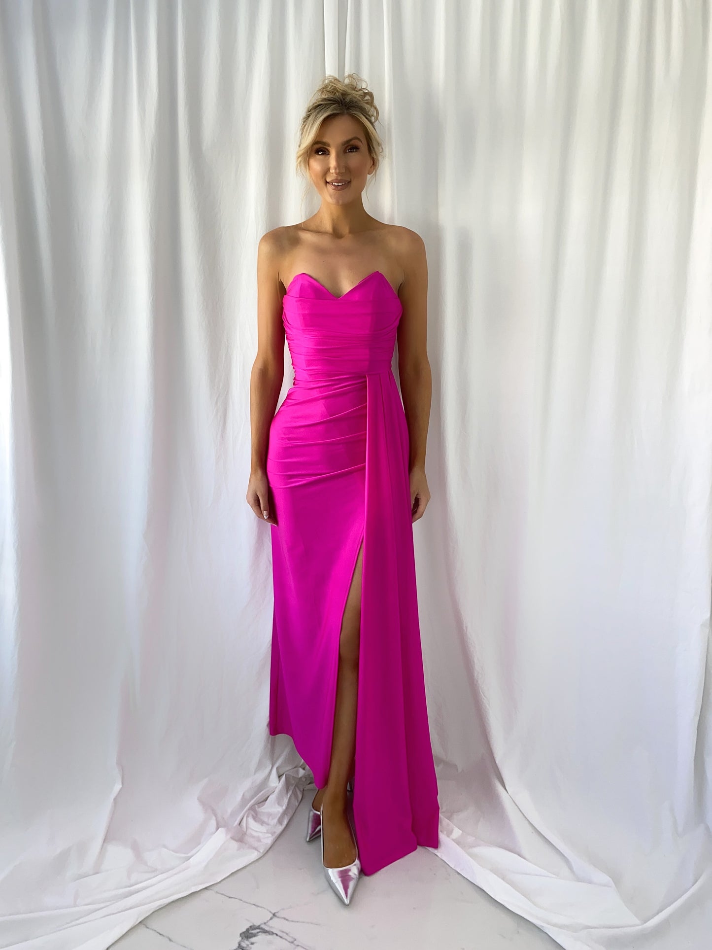 a woman in a pink dress standing in a white dress