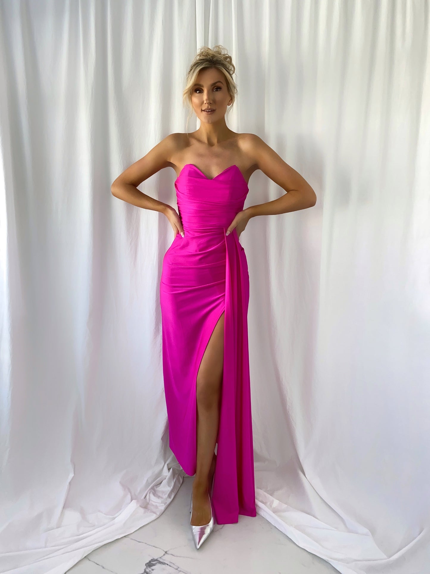 a woman in a pink dress holding a surfboard