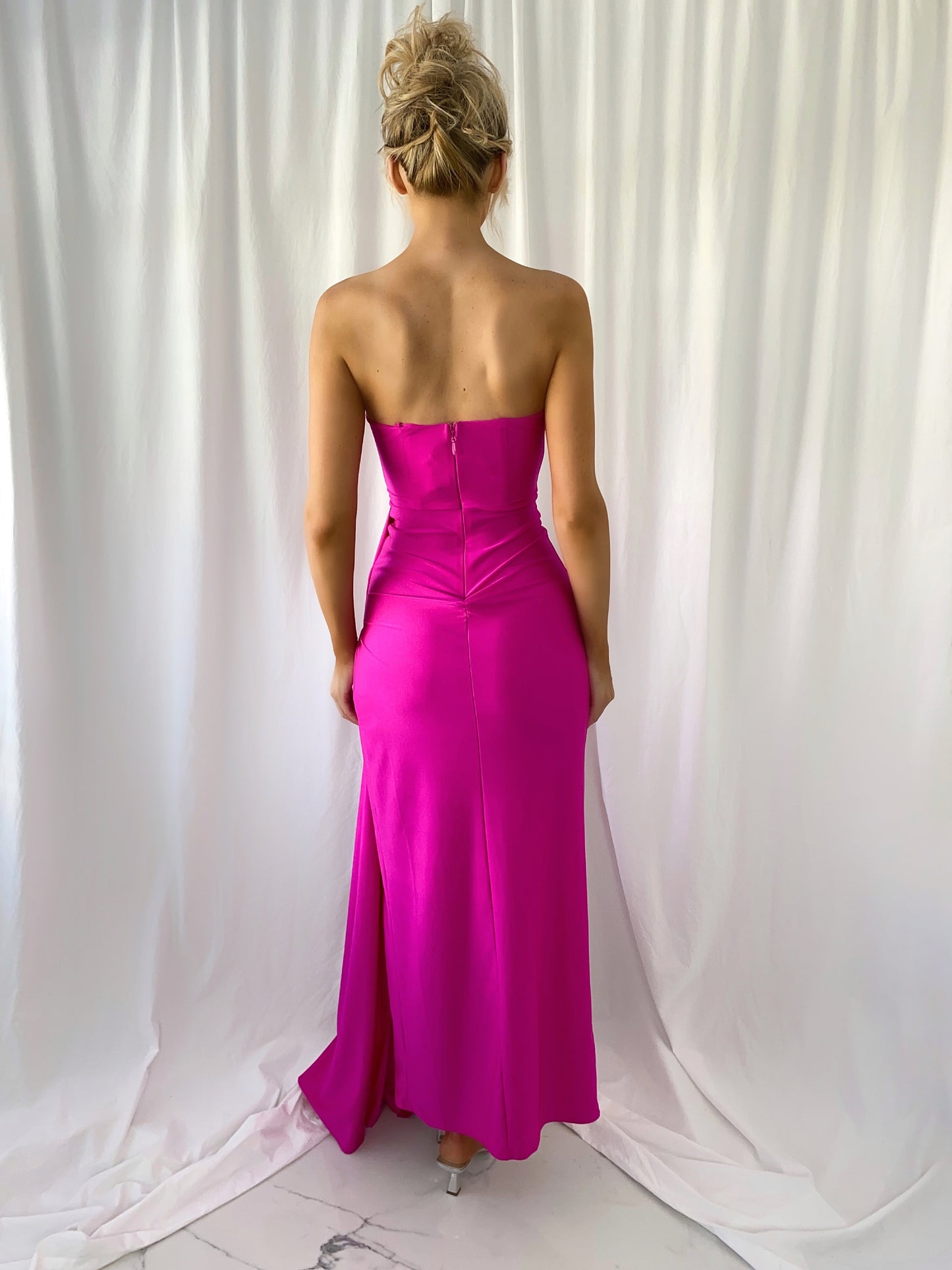 a woman in a pink dress standing in a white dress