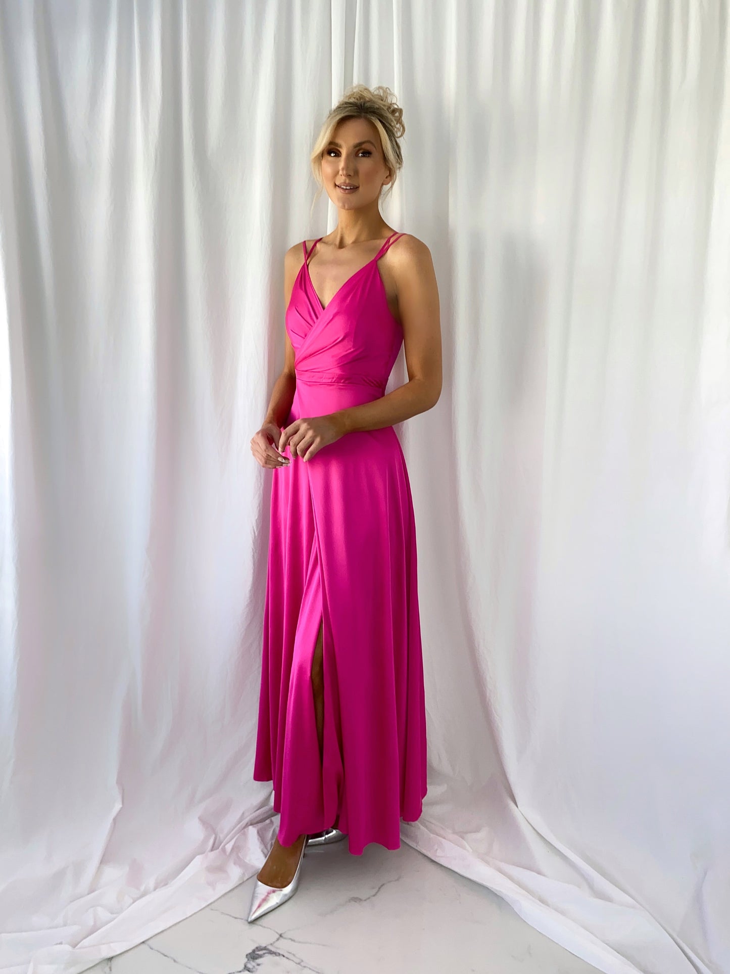 a woman in a pink dress standing in a white dress