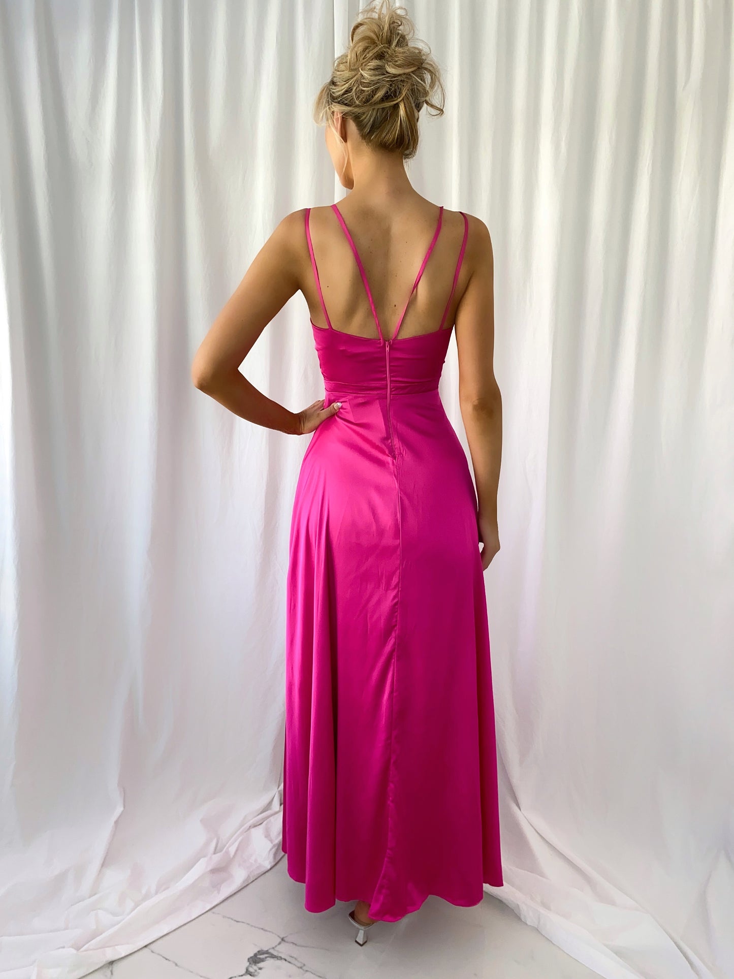 a woman in a pink dress standing in a white dress