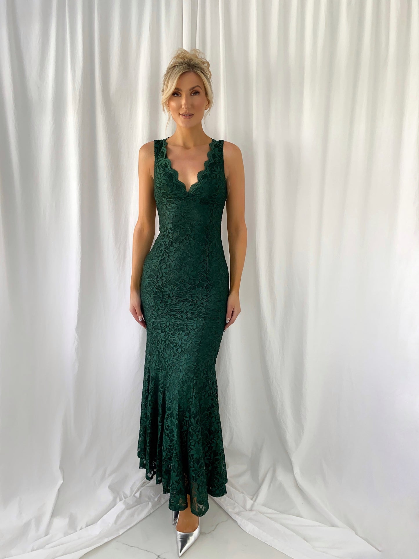 a woman in a green dress is talking on a cell phone