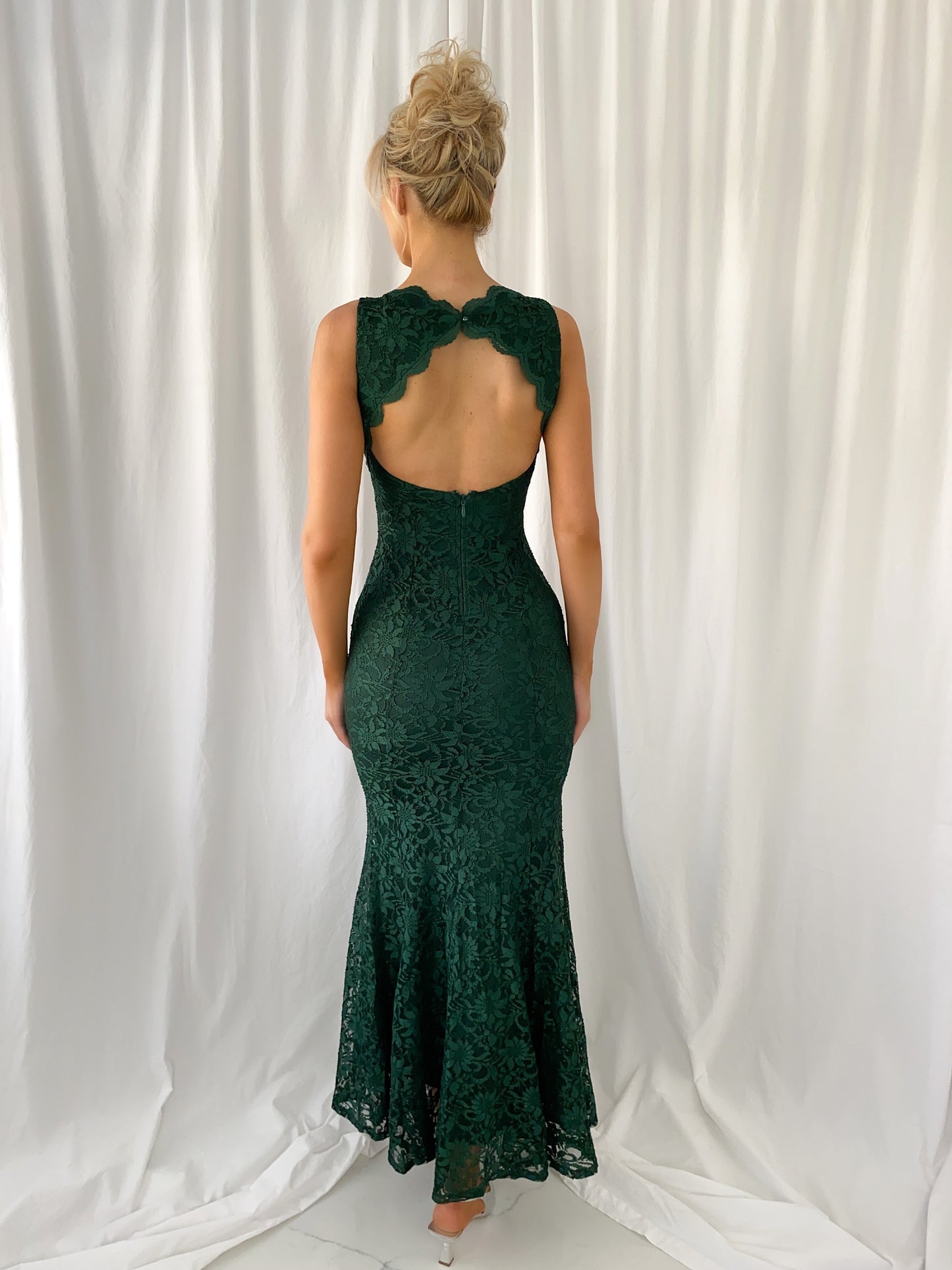 a woman in a green dress standing in a white dress