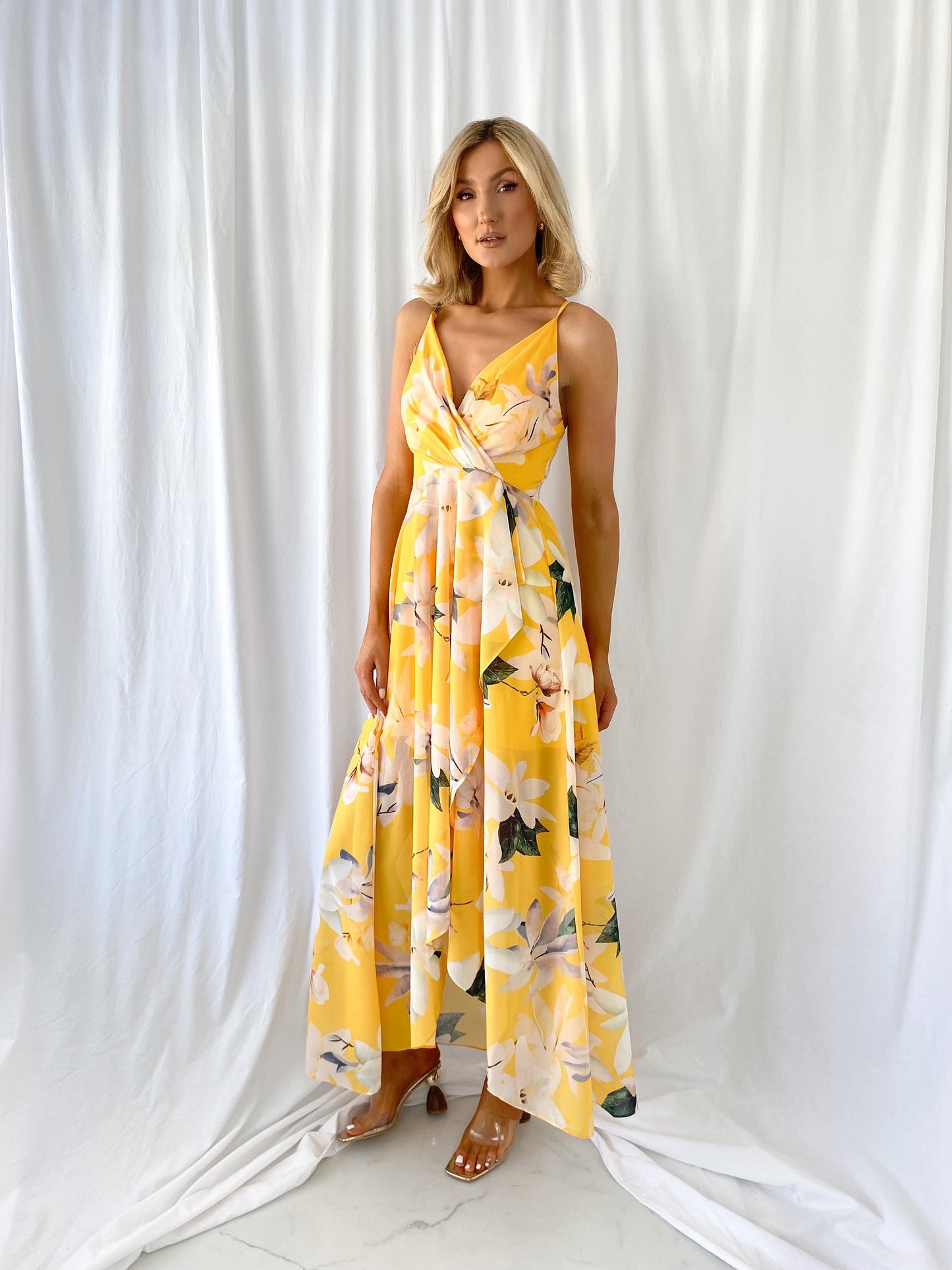 a woman in a yellow dress standing in the snow 