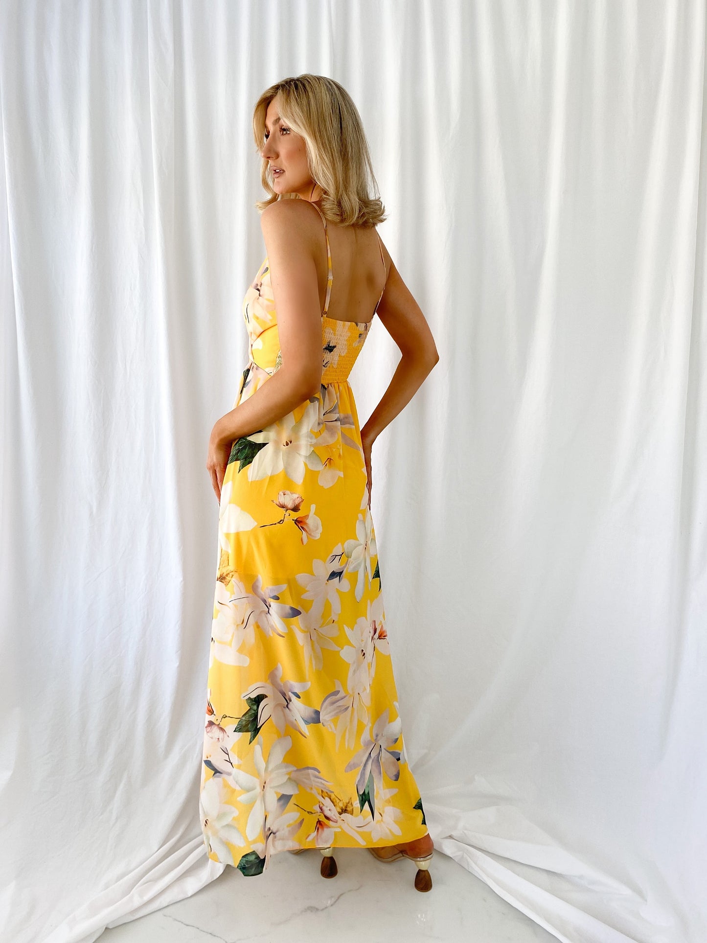 a woman in a yellow dress holding a yellow fire hydrant