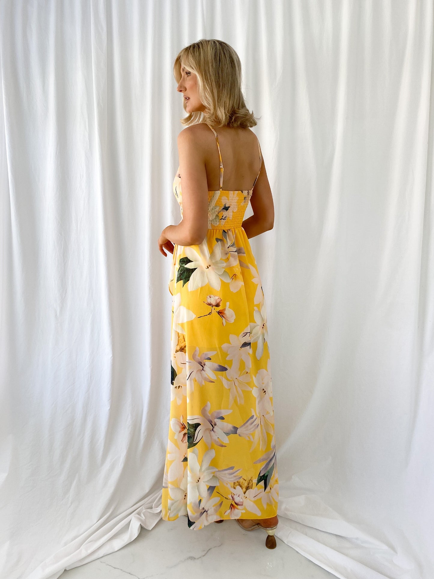 a woman in a yellow dress holding a yellow dress