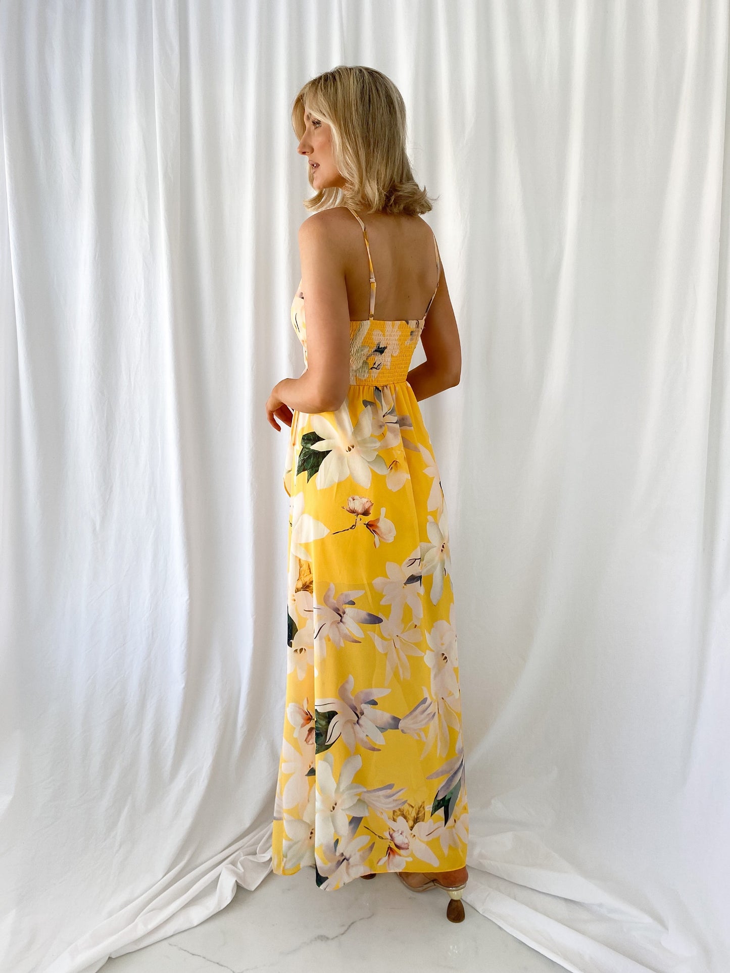 a woman in a yellow dress holding a yellow dress 