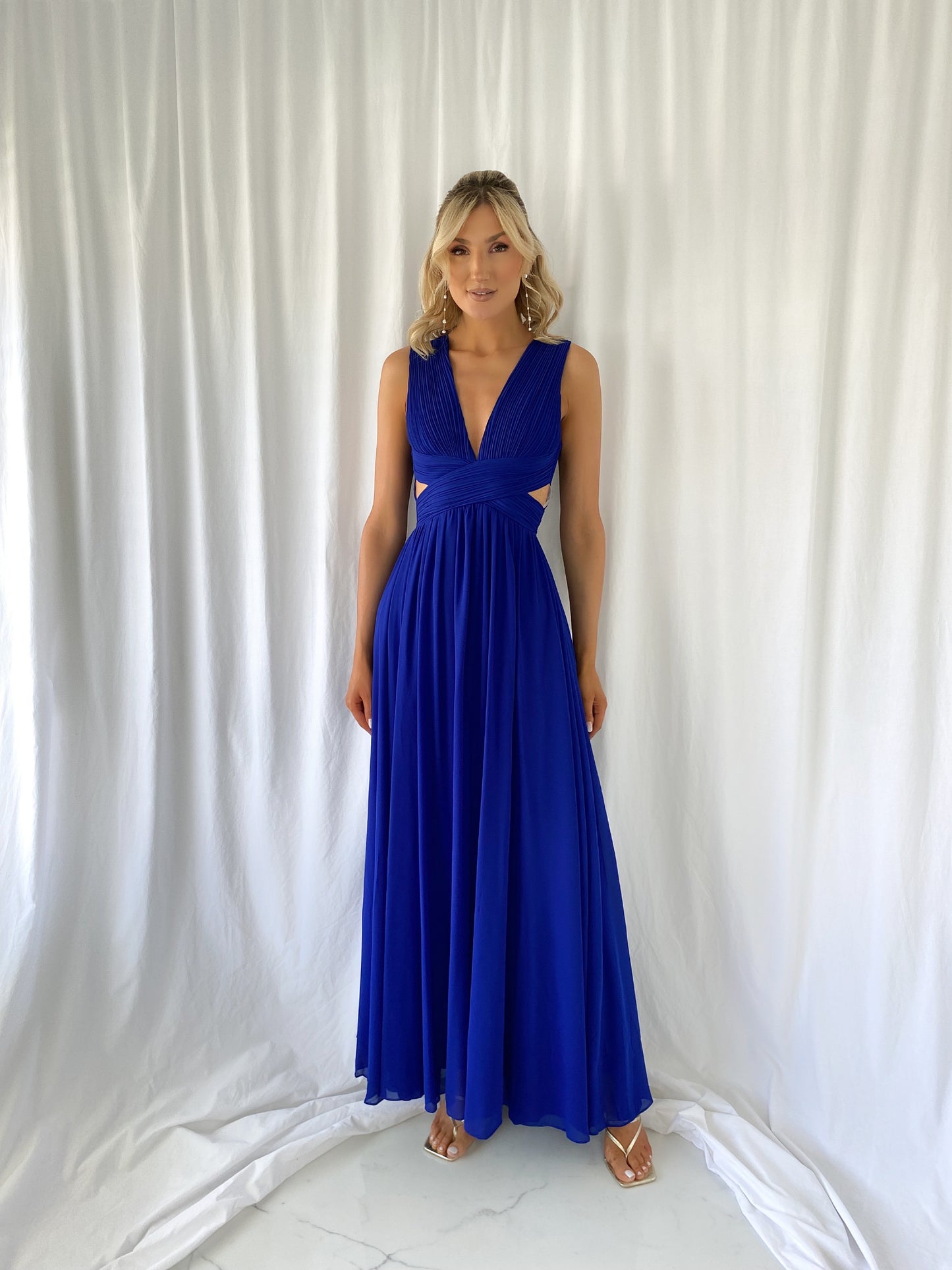 a woman in a blue dress talking on a cell phone