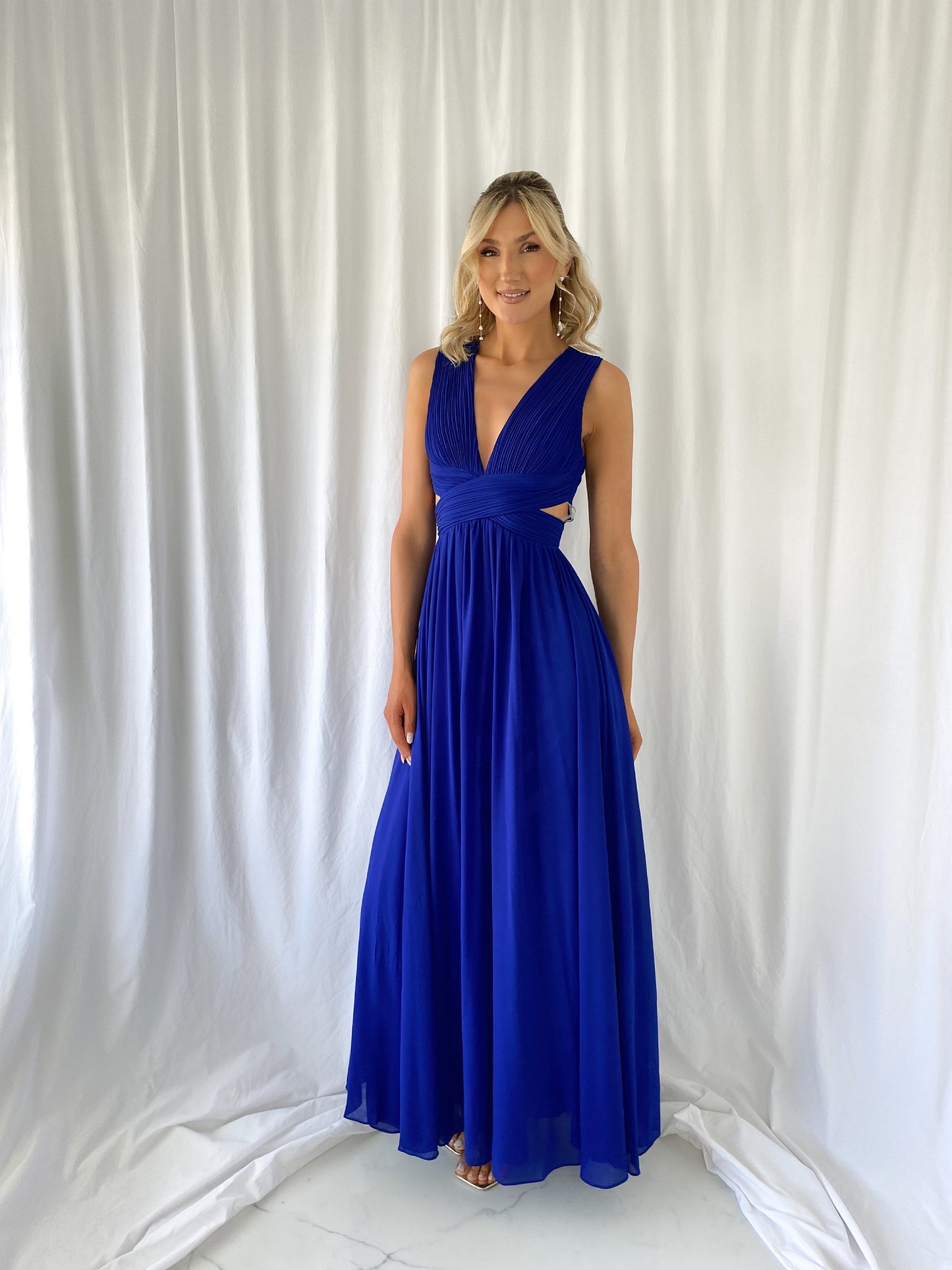 a woman in a blue dress talking on a cell phone