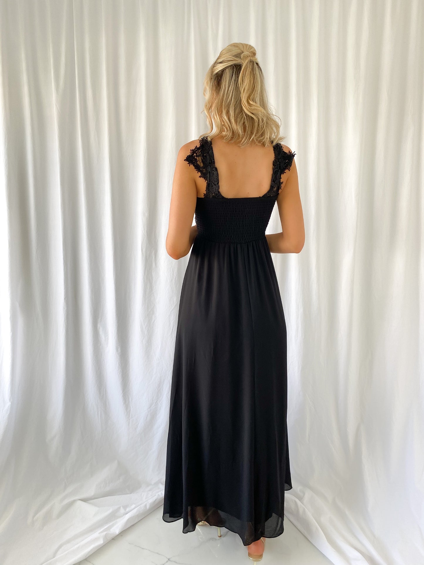 a woman in a white dress talking on a cell phone