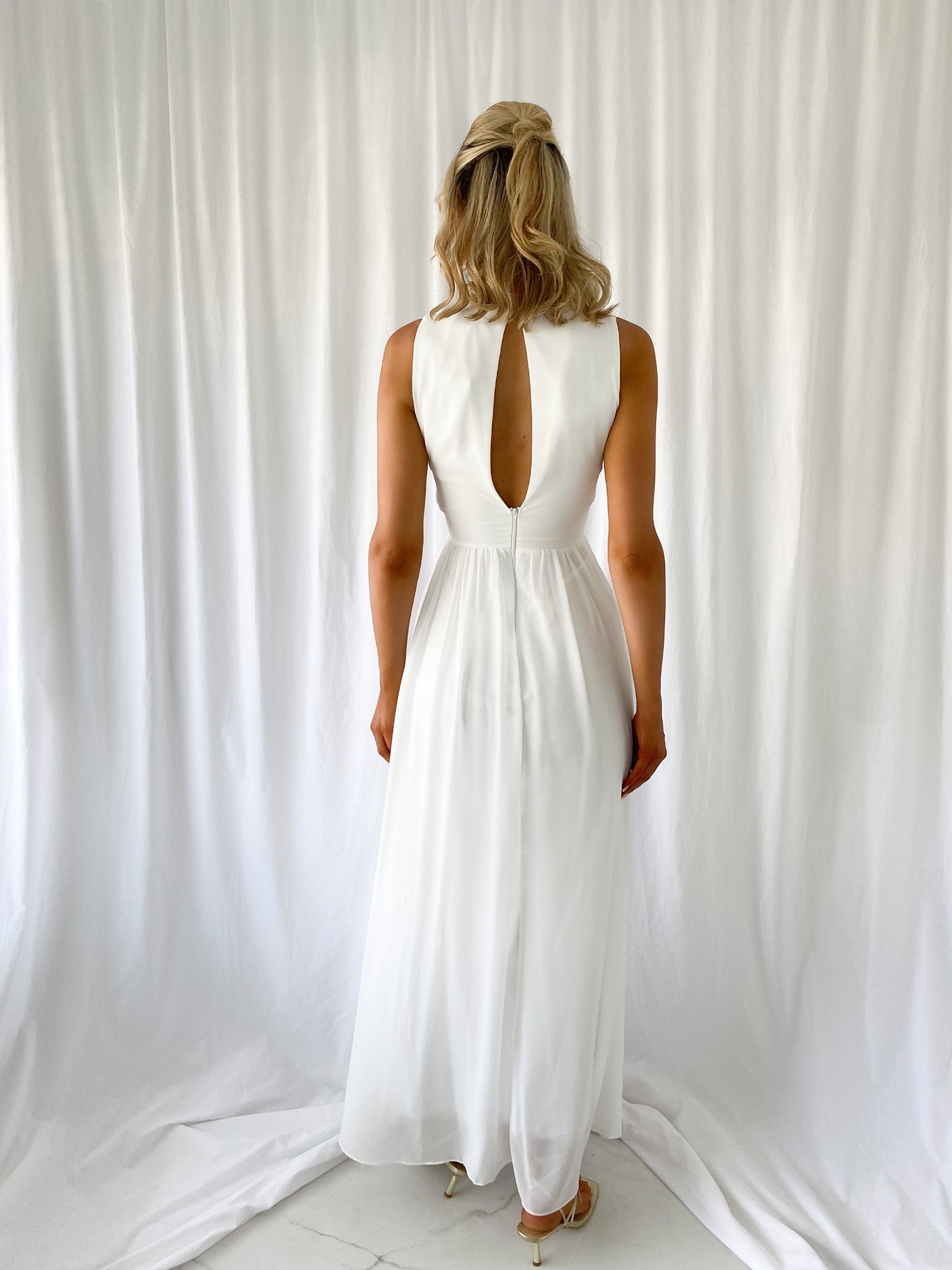 a woman in a white dress standing in a white dress 