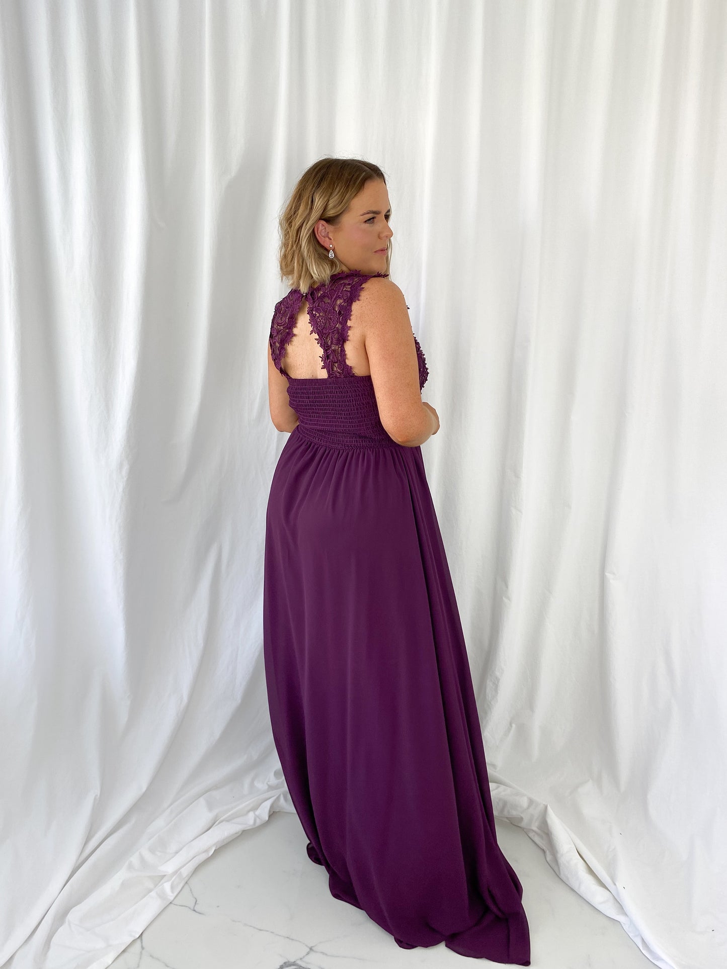 a woman in a pink dress is talking on a cell phone