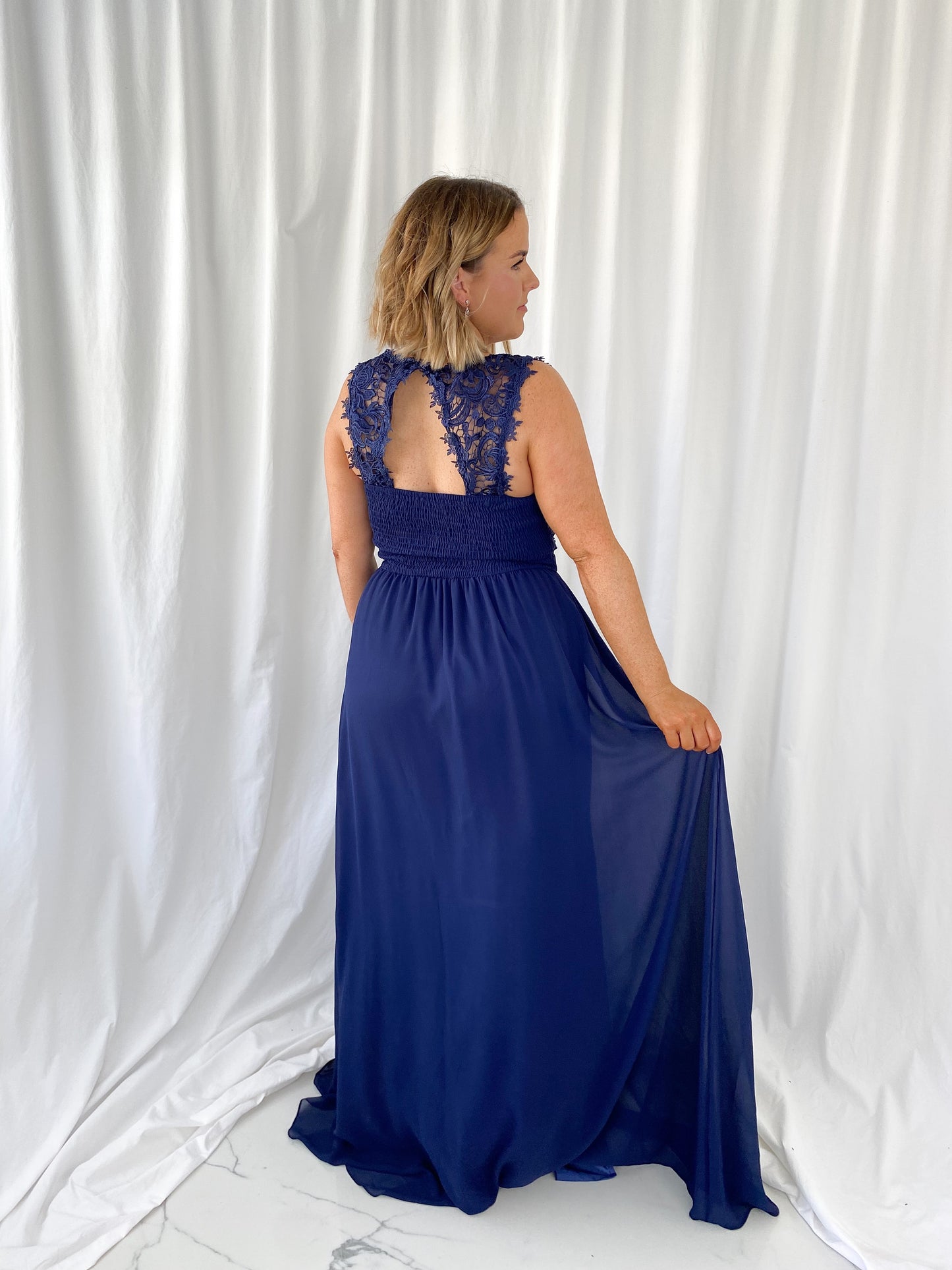 a woman in a blue dress standing in the snow