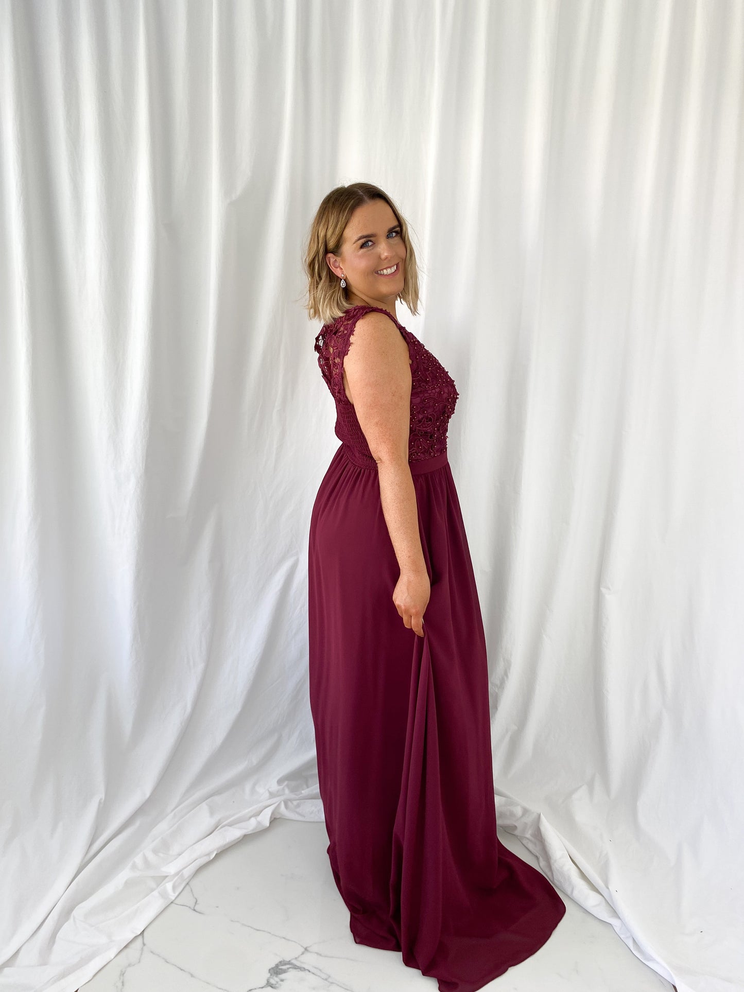 a woman in a red dress talking on a cell phone