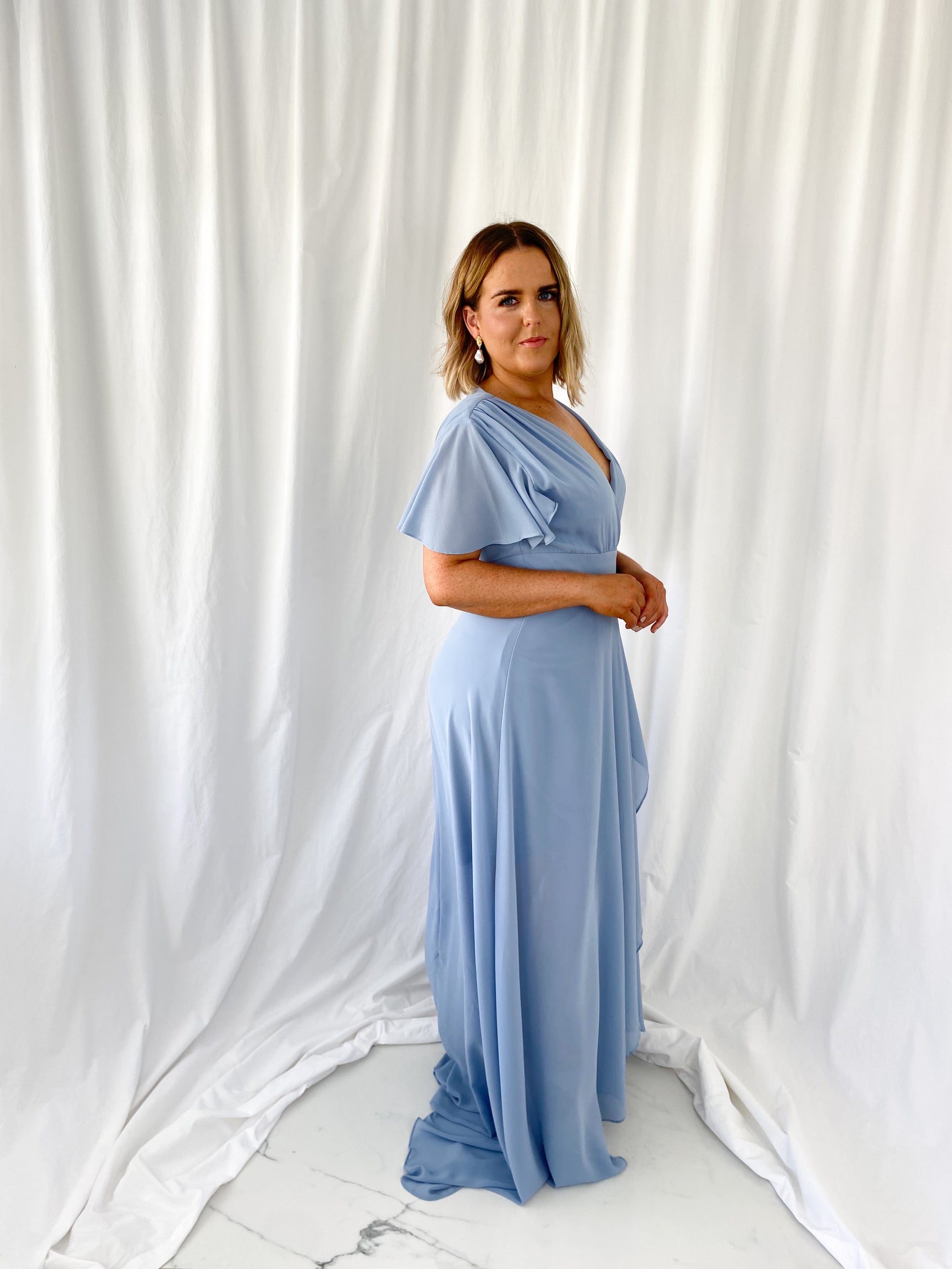 a woman standing on a bed with a tie