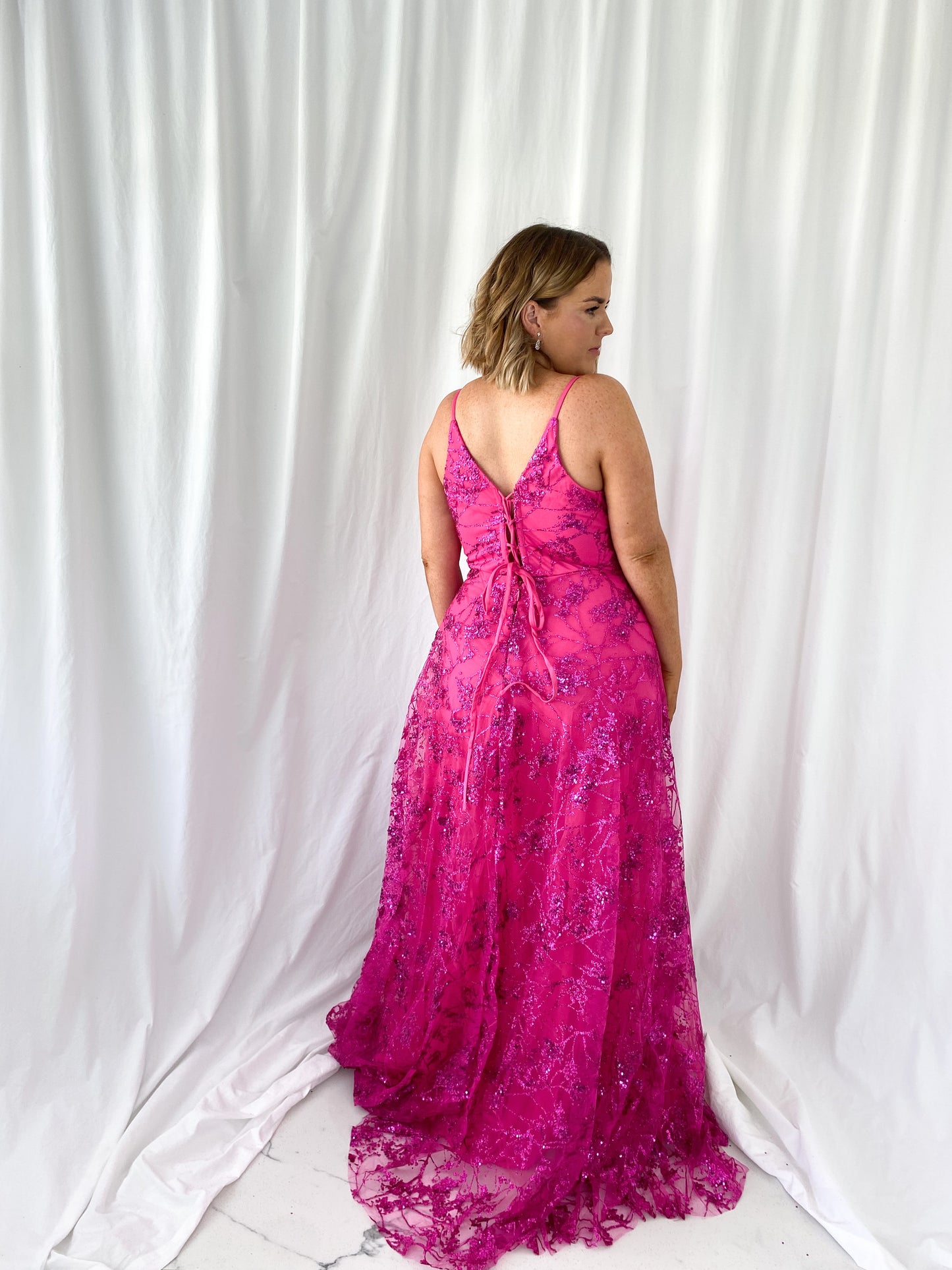 a woman in a pink dress standing in a white dress