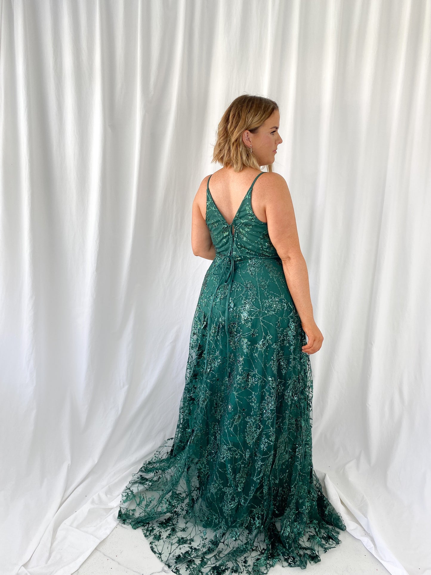 a woman in a green dress is talking on a cell phone