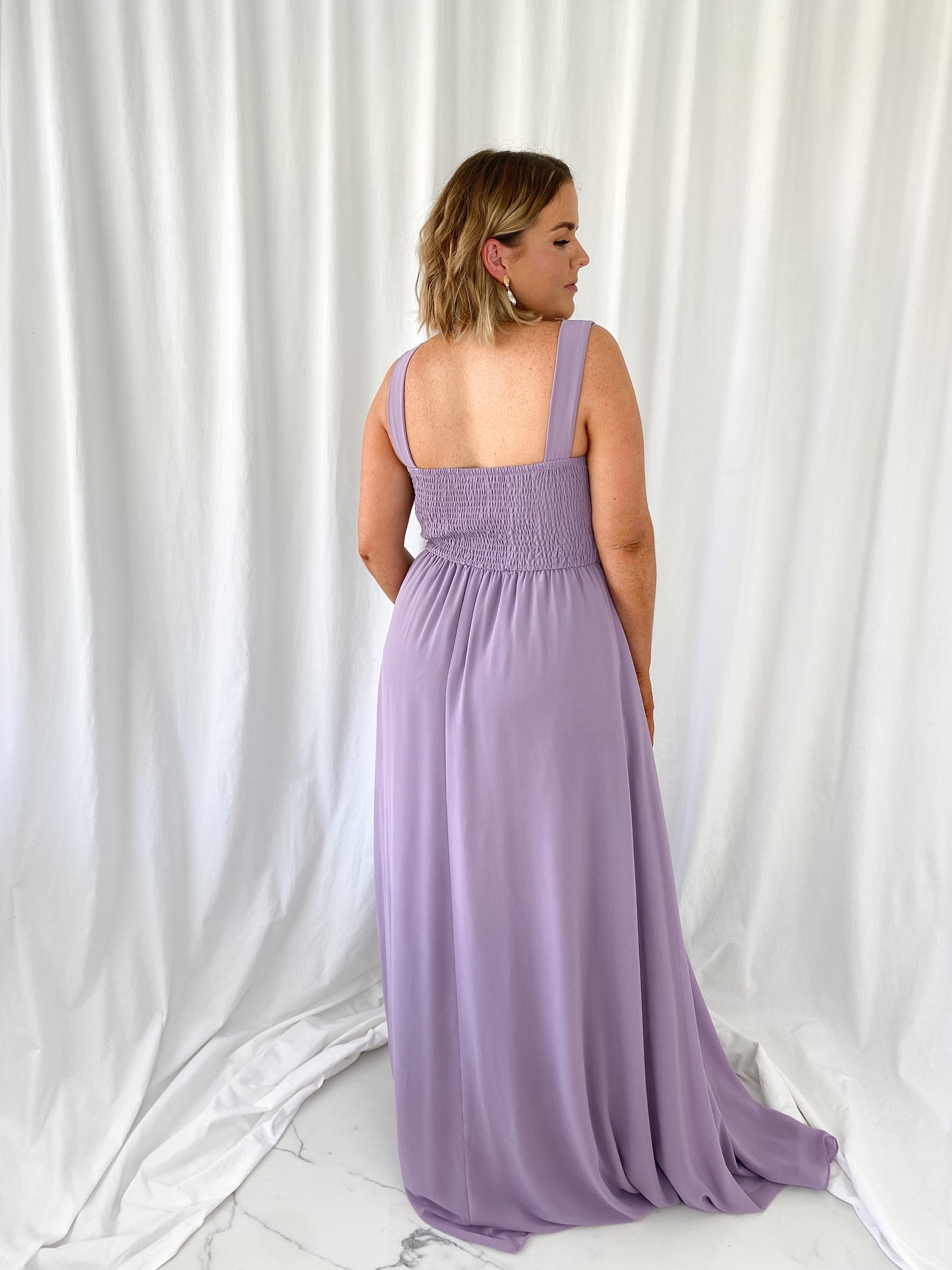 a woman in a pink dress is talking on a cell phone