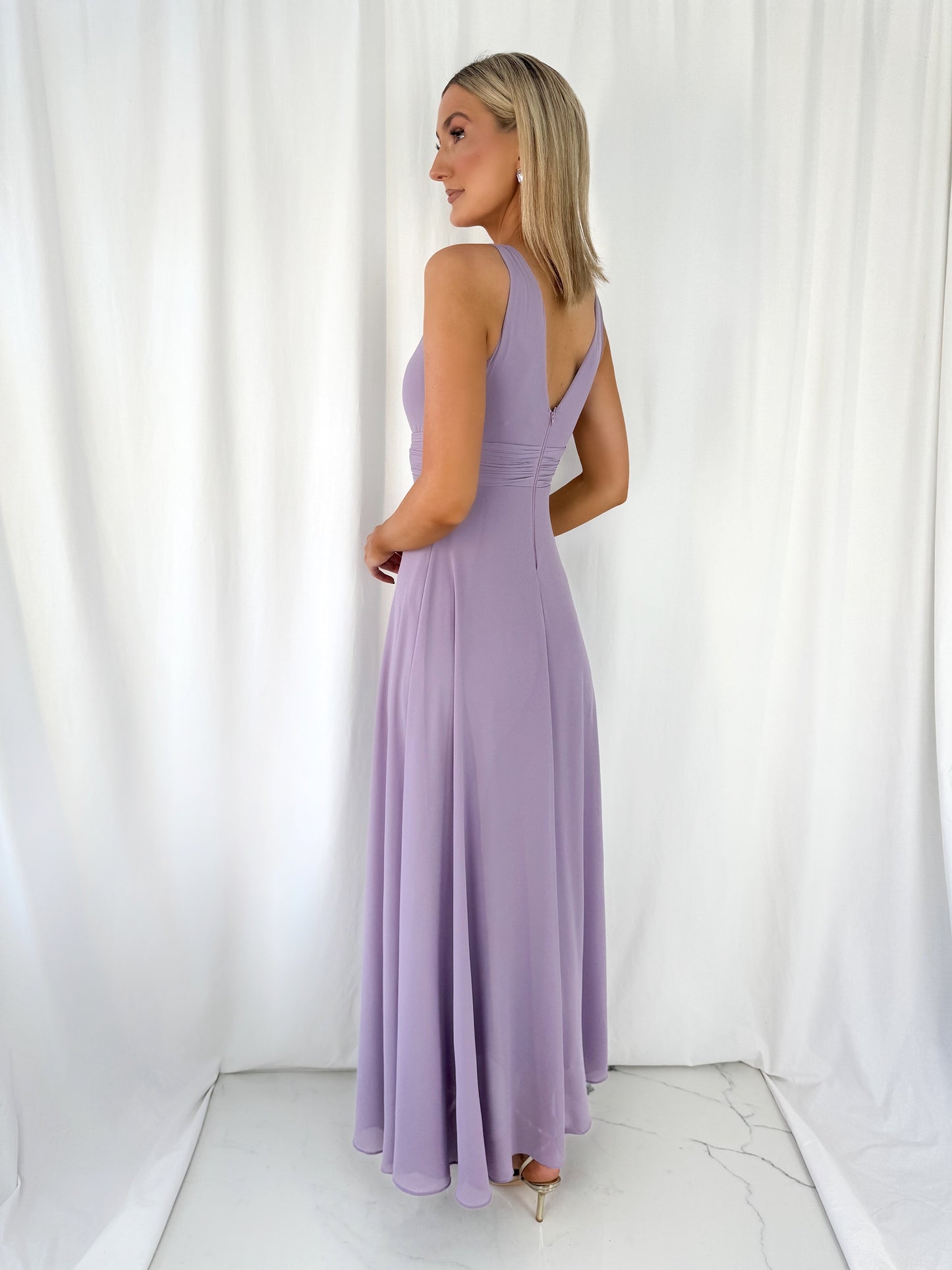 a woman in a white dress talking on a cell phone