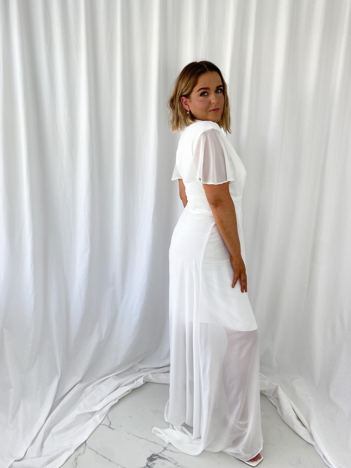 a man in white is holding a tennis racket