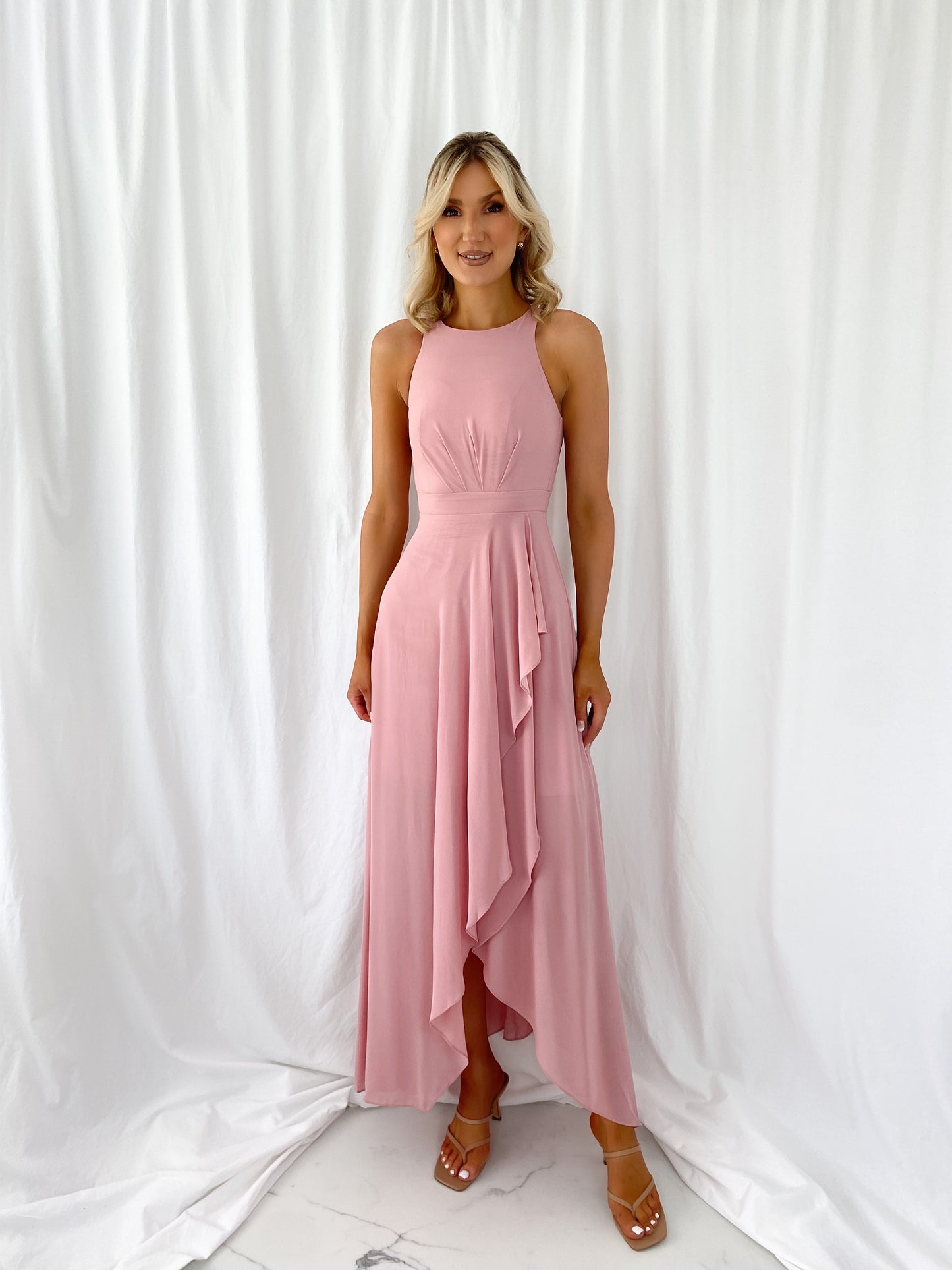 a woman in a pink dress standing in a white dress