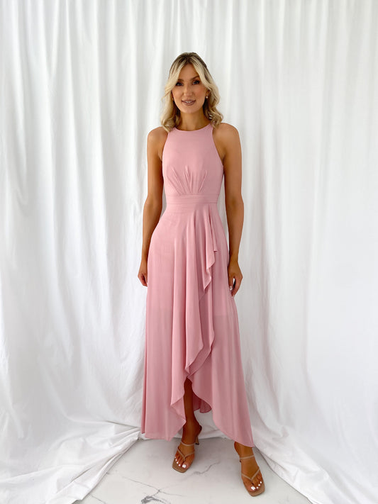 a woman in a pink dress standing in a white dress