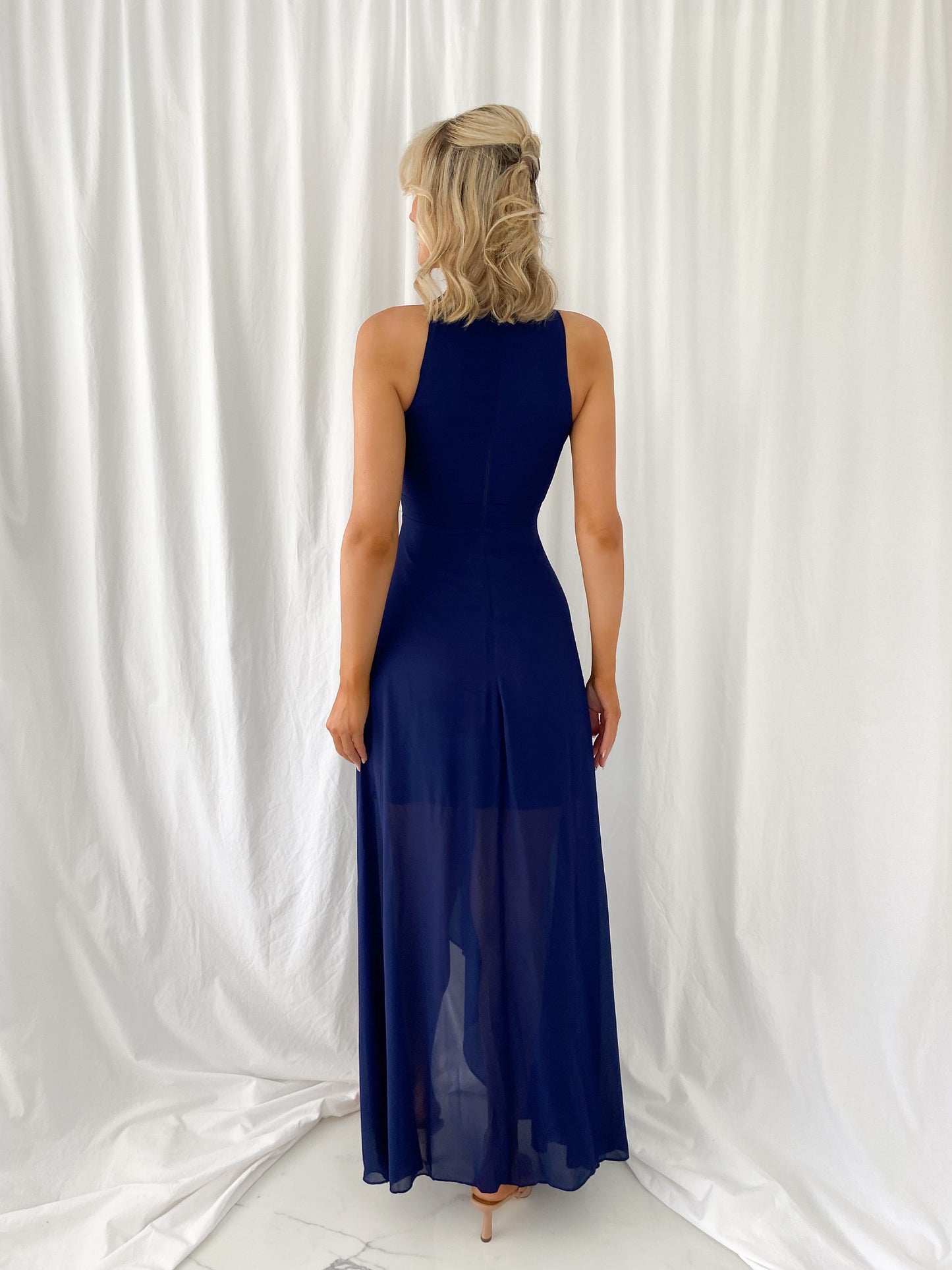a woman in a blue dress standing in a white dress