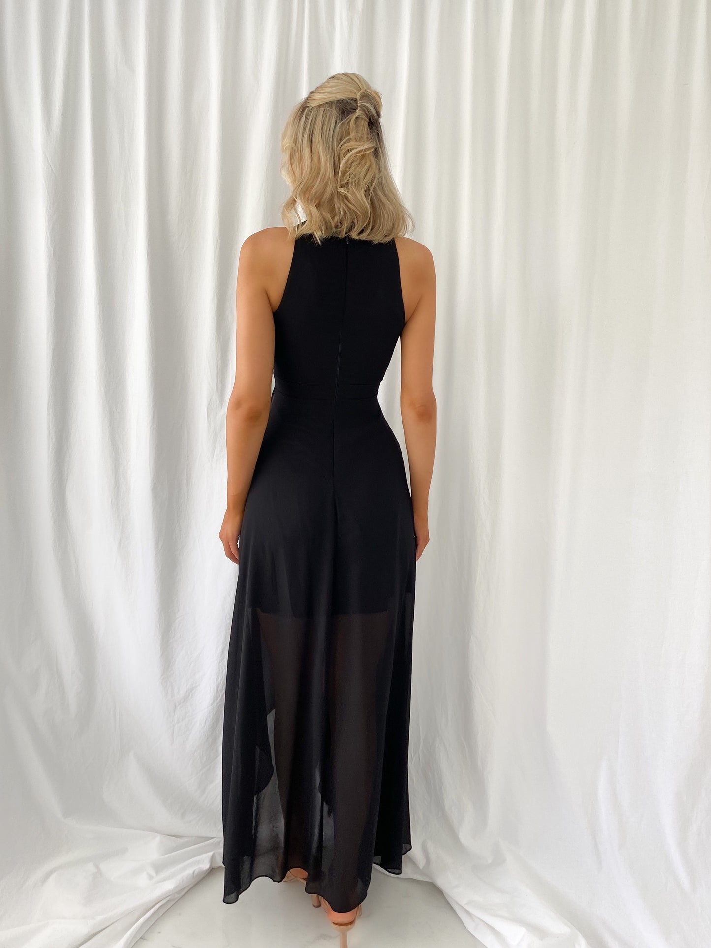 a woman in a black dress is holding a purse