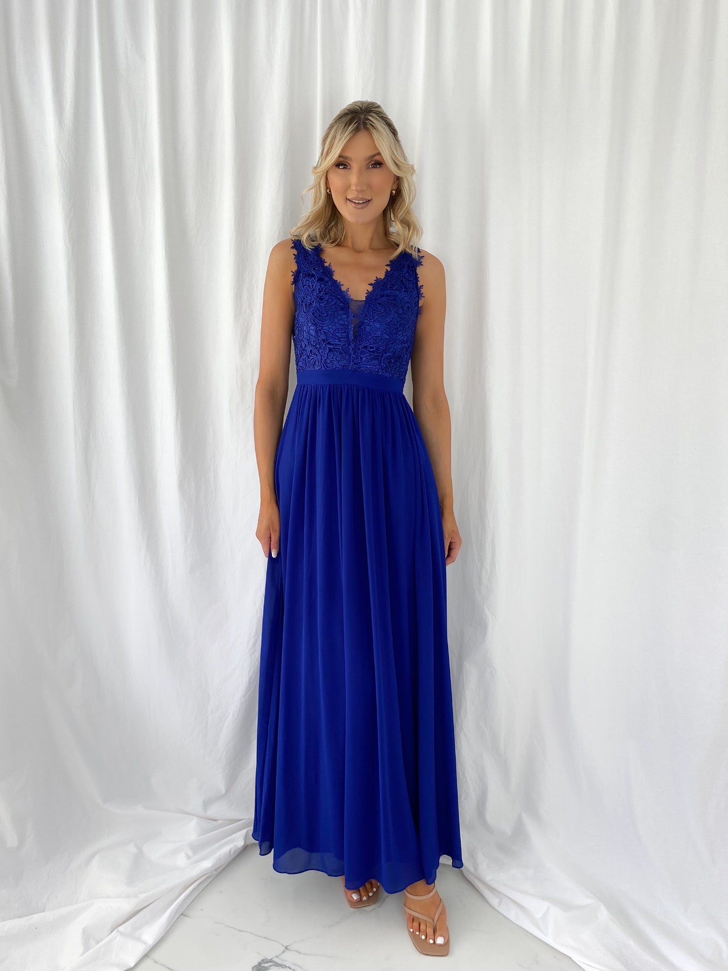 a woman in a blue dress talking on a cell phone