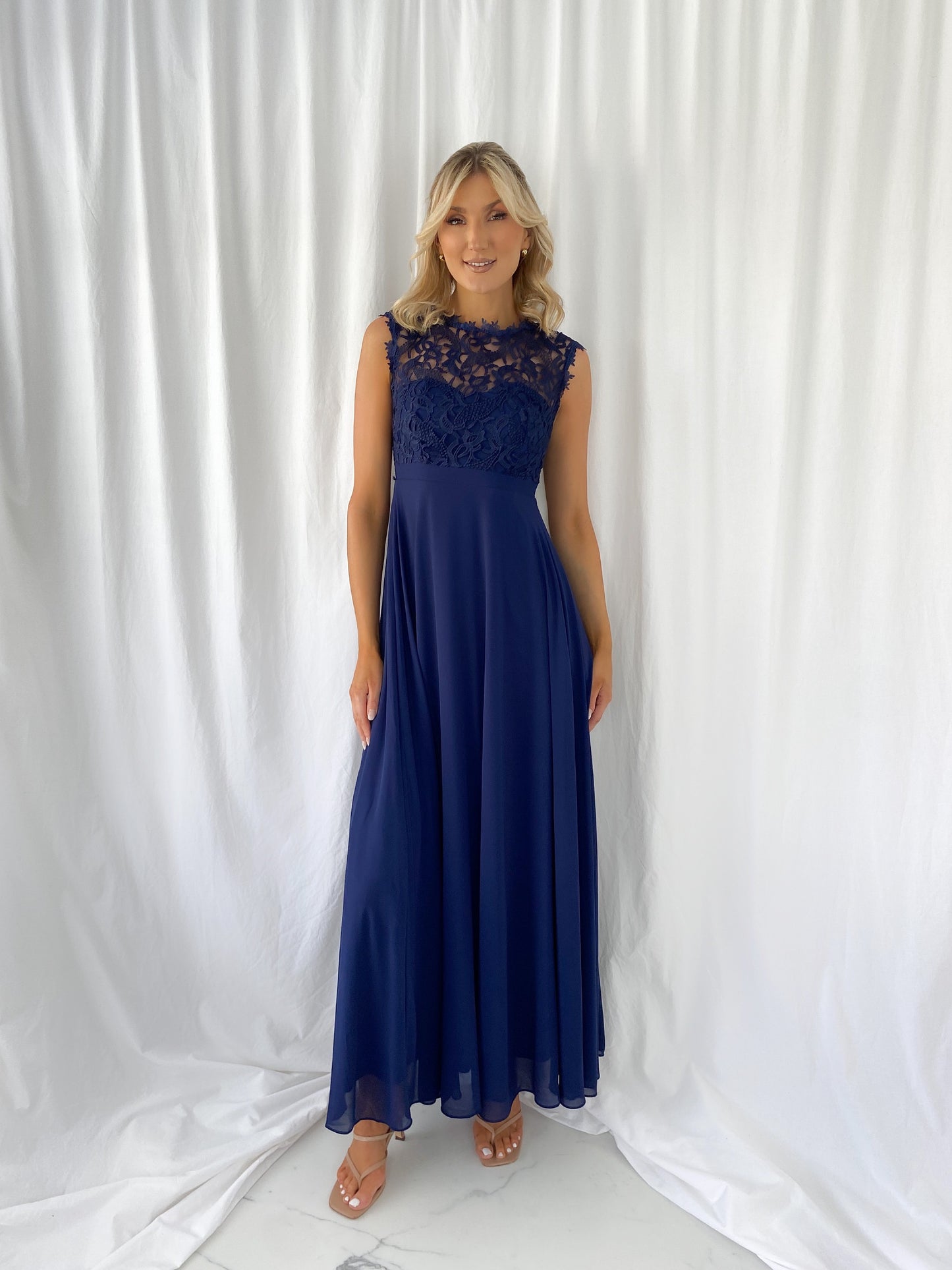 a woman in a blue dress standing in a white dress