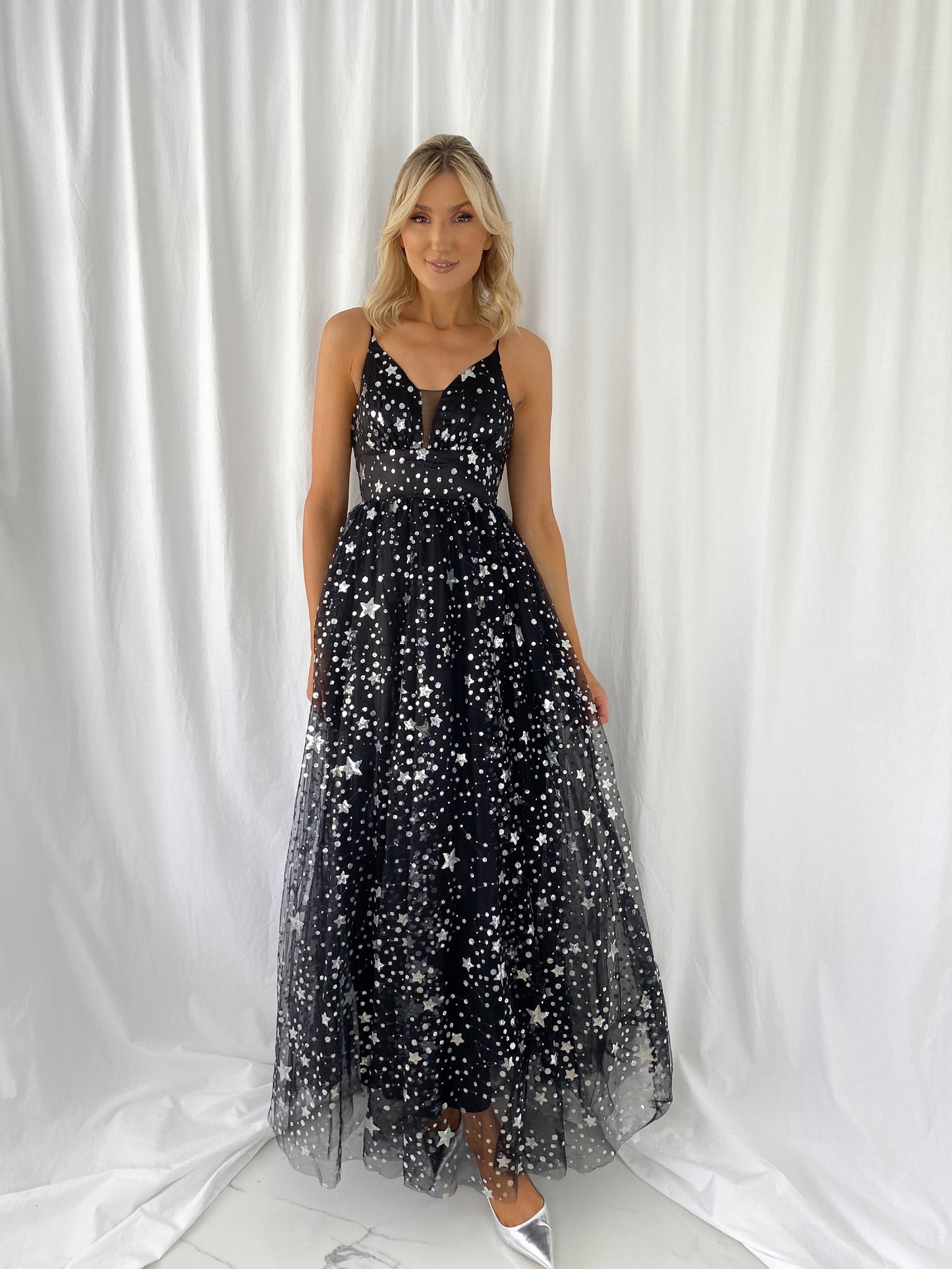 a woman in a black dress on a surfboard